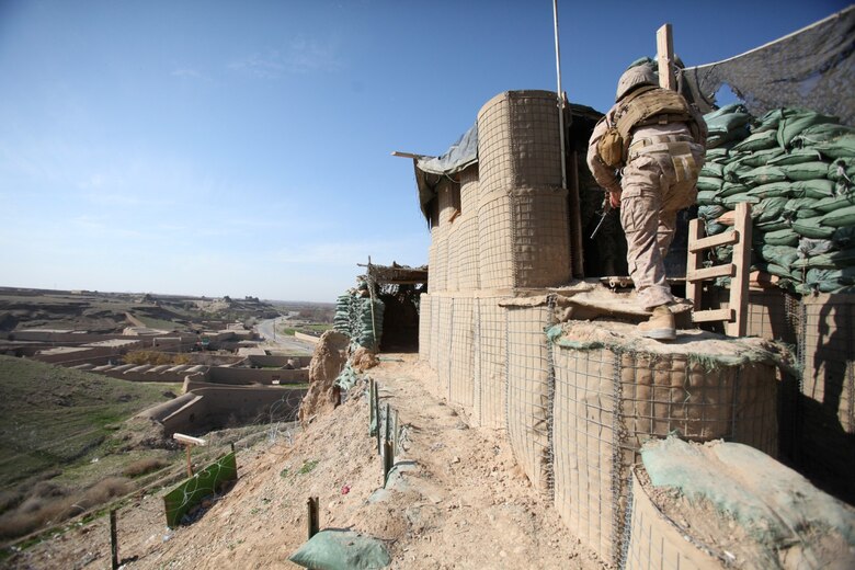 A Marine with Security Force Assistance Advisor Team 2-215 climbs an outpost which overlooks the Sangin Valley near Forward Operating Base Robinson, Helmand province, Afghanistan, Feb. 24, 2014. The Marines were invited to the outpost to see the progress that was made in a recent operation, Oqab 144.