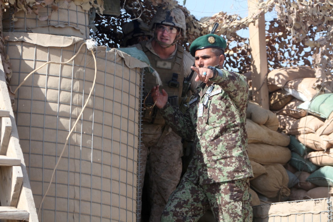 Colonel AbdulHai Neshat, the executive officer of 2nd Brigade, 215th Corps, Afghan National Army, shows a Marine with Security Force Assistance Advisor Team 2-215 an outpost near Forward Operating Base Robinson, Feb. 24, 2014. Neshat expressed his confidence in the ability of the 2nd Brigade to hold their positions and facilitate the upcoming Afghan presidential elections.