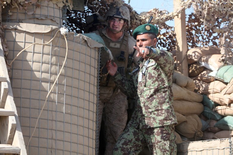 Colonel AbdulHai Neshat, the executive officer of 2nd Brigade, 215th Corps, Afghan National Army, shows a Marine with Security Force Assistance Advisor Team 2-215 an outpost near Forward Operating Base Robinson, Feb. 24, 2014. Neshat expressed his confidence in the ability of the 2nd Brigade to hold their positions and facilitate the upcoming Afghan presidential elections.