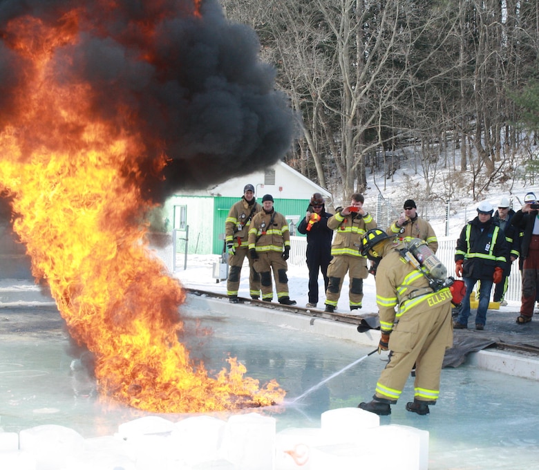 A Hanover, N.H., firefighter takes advantage of a unique opportunity to extinguish burning North Slope crude oil.  The burning is part of Alaska Clean Seas’ Advanced oil Response in Ice course, program to train oil spill responders.  The fire department’s presence was requested as a precaution, but resulted in training for them as well.  Burning oil is an environmentally accepted and extremely efficient method of mitigating oil spills in ice-infested water.