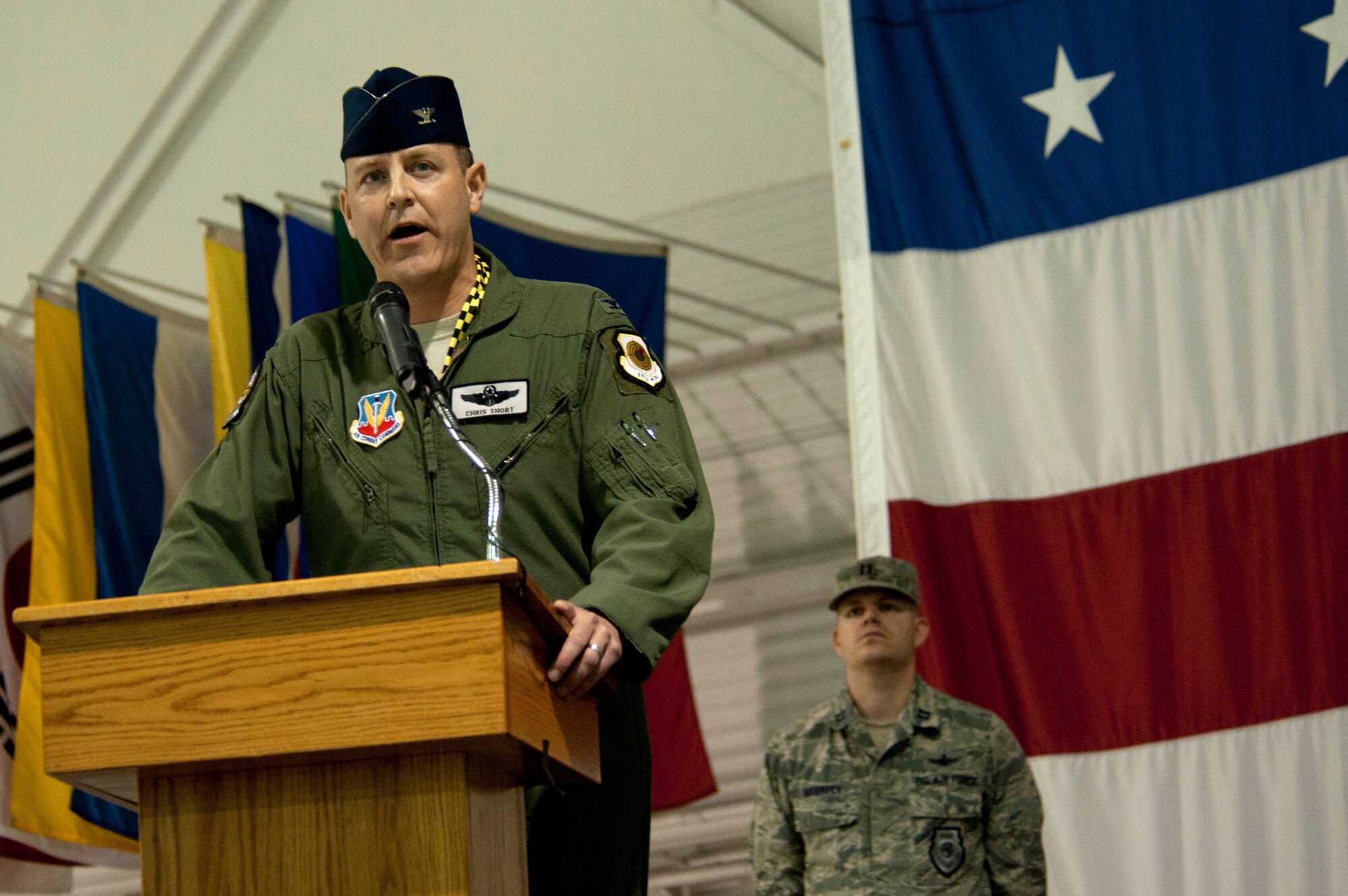 Col. Christopher Short, 57th Wing commander, speaks to  Airmen during the 57th WG change of command ceremony in the Thunderbird hanger Feb. 28, 2014 at Nellis Air Force Base, Nev.  Short is responsible for 39 squadrons at 12 installations comprising the Air Force's most diverse flying wing. (U.S. Air Force photo by Airman 1st Class Timothy Young)
