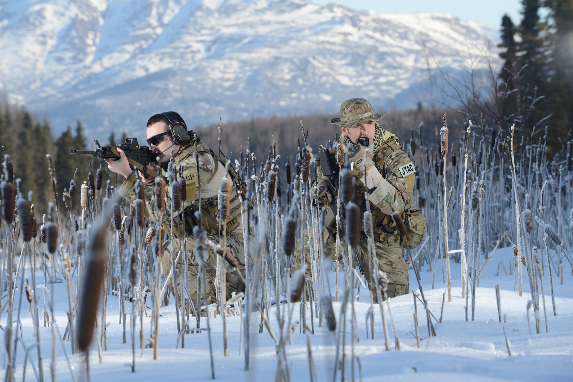 U.S. Air Force Capt. Jack Fine (left) and Senior Airman Sergio Barcena-Turner, both assigned to the 3rd Air Support Operations Squadron, simulate a patrol at Sixmile Lake, Joint Base Elmendorf-Richardson, Alaska, March 3, 2014. JBER is home to 3rd ASOS joint terminal attack controllers, whose primary responsibility is to advice the ground commander on proper utilization of air power. (U.S. Air Force photo/Staff Sgt. Sheila deVera)