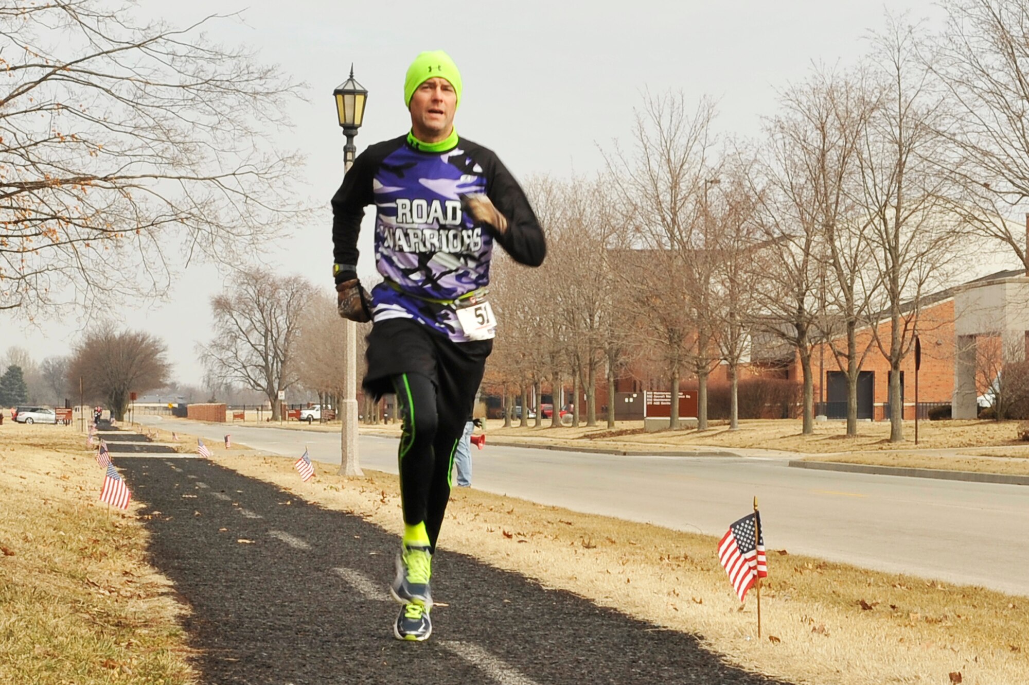 Tom Reay follows the 5k route marked by American flags. Runners competed in groups based on age and gender. (U.S. Air Force photo/ Airman 1st Class Kiana Brothers)