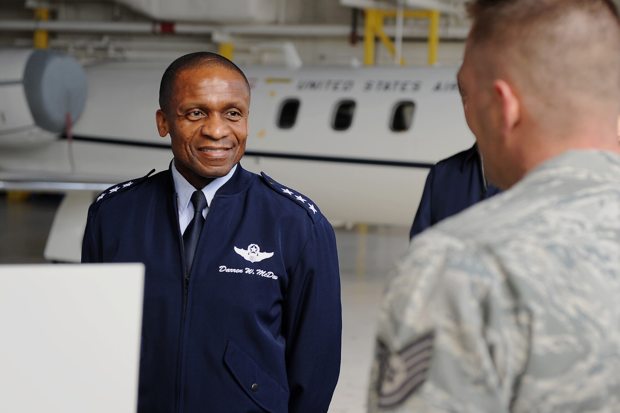 Lt. Gen. Darren W. McDew, 18th Air Force commander, receives a briefing from Tech. Sgt. Joe Gatchell, 458th Airlift Squadron, during an official visit here Feb. 28, 2014 at Scott Air Force Base, Ill. Gatchell briefed McDew on new equipment being used aboard the C-21. (U.S. Air Force photo/Senior Airman Divine Cox)
