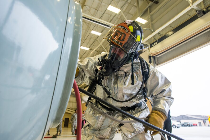 Jacob Charles, 23d Civil Engineer Squadron fire department driver operator, feeds air tubing into a fuselage tank at Moody Air Force Base, Ga., Mar. 4, 2014. Charles worked with a team of Moody firefighters to remove an incapacitated Airman from a confined space during a yearly training exercise. (U.S. Air Force photo by Airman 1st Class Ryan Callaghan/Released)
