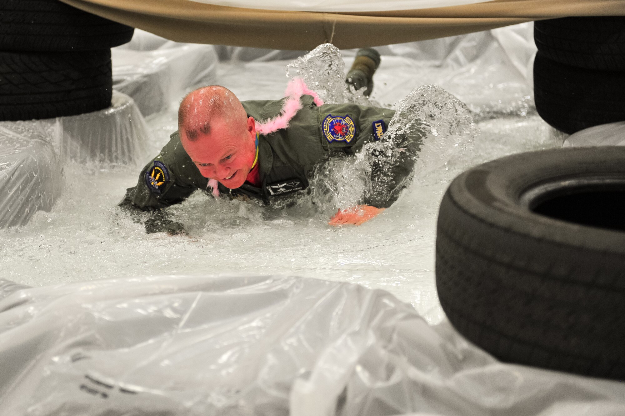Air Force Reserve Chief Master Sgt. Robert Cherry makes his way through a water-soaked obstacle course March 1, 2014, during the 310th Space Wing's Combat Dining In/Annual Awards Ceremony at Peterson Air Force Base, Colo. The wing sponsored the event to both recognize its annual award winners and bring together the Reservists for an evening of esprit de corps, unit morale and camaraderie. Cherry is assigned to the 310th Operations Support Squadron. (U.S. Air Force photo/Tech. Sgt. Nicholas B. Ontiveros)