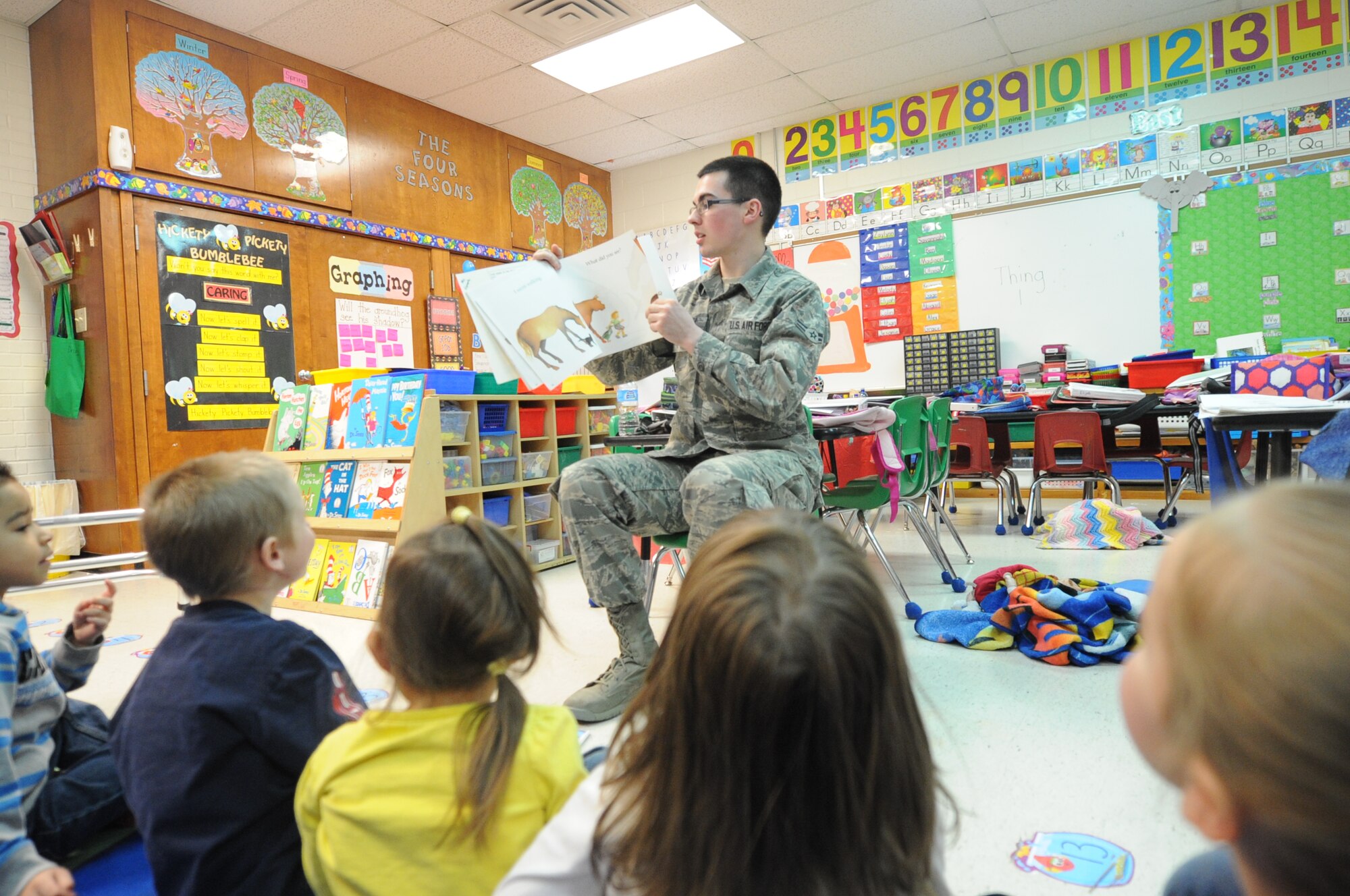 ALTUS AIR FORCE BASE, Okla. – U.S. Air Force Airman 1st Class John Kavanagh, 97th Contracting Squadron contract specialist, reads a book to a kindergarten class as part of the Read Across America program at L. Mendel Rivers Elementary School March 3, 2014. Read Across America is a nationwide program that helps children develop a love for reading by making it fun. (U.S. Air Force photo by Senior Airman Levin Boland/Released) 
