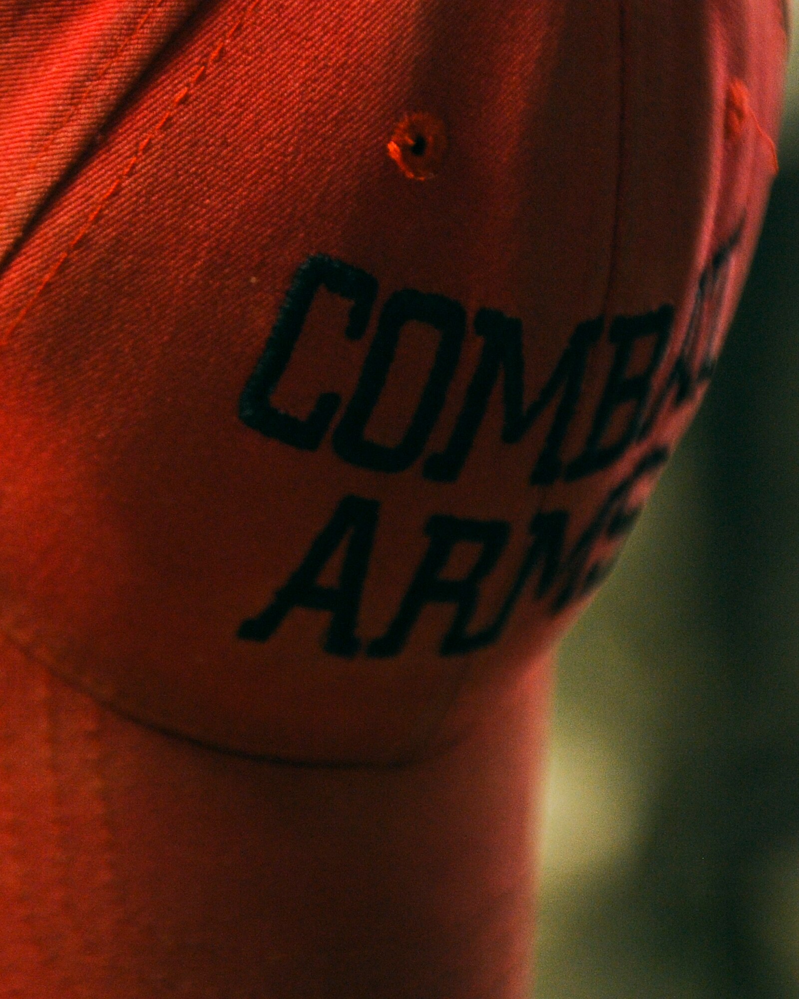 An Airman dons a combat arms hat on Hurlburt Field, Fla., March 3, 2014. Combat arms Airmen wear the distinctive red caps to mark them as range safety officers while Airmen receive weapons training. (U.S. Air Force photo/Senior Airman Michelle Patten) 