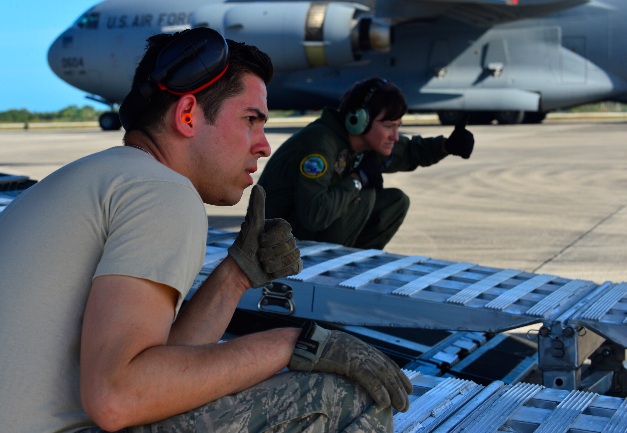 Tech Sgt. Kurtis Ernst, 46th Aerial Port Squadron special handling craftsman and Master Sgt. Michelle Hite, 326th Airlift Squadron loadmaster, help direct vehicles and cargo into a C-17 Globemaster III during Operation Patriot Sands, Feb. 22, 2014 at Homestead Air Reserve Base, Fla. The Aerial Port members assisted the loadmasters in loading and securing trucks and equipment driven onto the aircraft by FEMA, FBI, and Florida Advanced Surgical Team to ensure everything is safe. (U.S. Air Force photo/Staff Sgt. Elizabeth Morris)