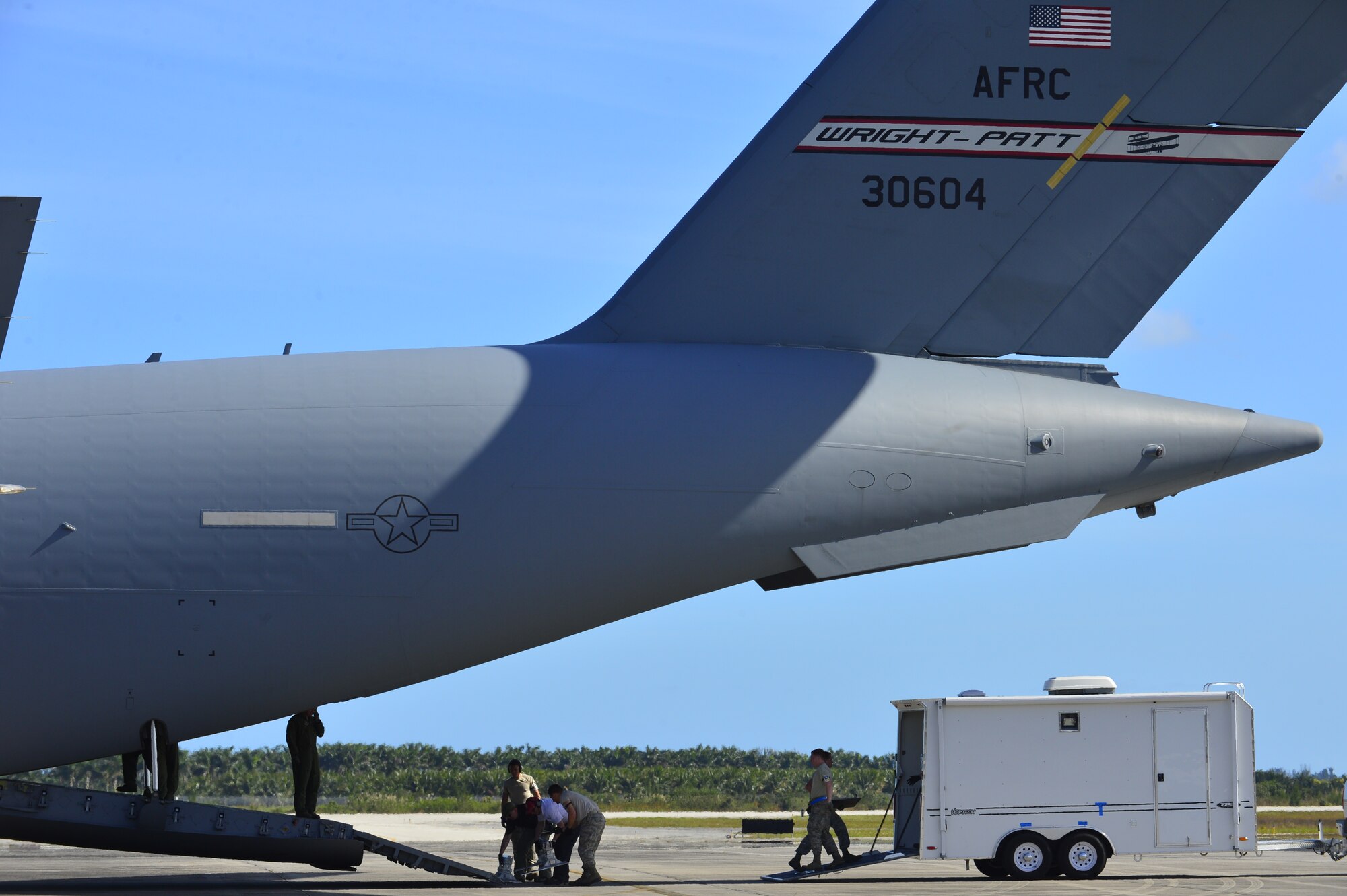 Airmen from the 46th Aerial Port Squadron work with a rapid deployment team from the Washington Field Office of the Federal Bureau of Investigations to unload their equipment from a C-17 Globemaster III during Operation Patriot Sands, Feb. 22, 2014 at Homestead Air Reserve Base, Fla. The purpose of the exercise was to test and train on the FBI, FEMA and Florida Advanced Surgical Team’s ability to deploy on military airlift and for the Airmen to train and practice their ability to assert command, control and communication in bare base conditions. (U.S. Air Force photo/Staff Sgt. Elizabeth Morris)