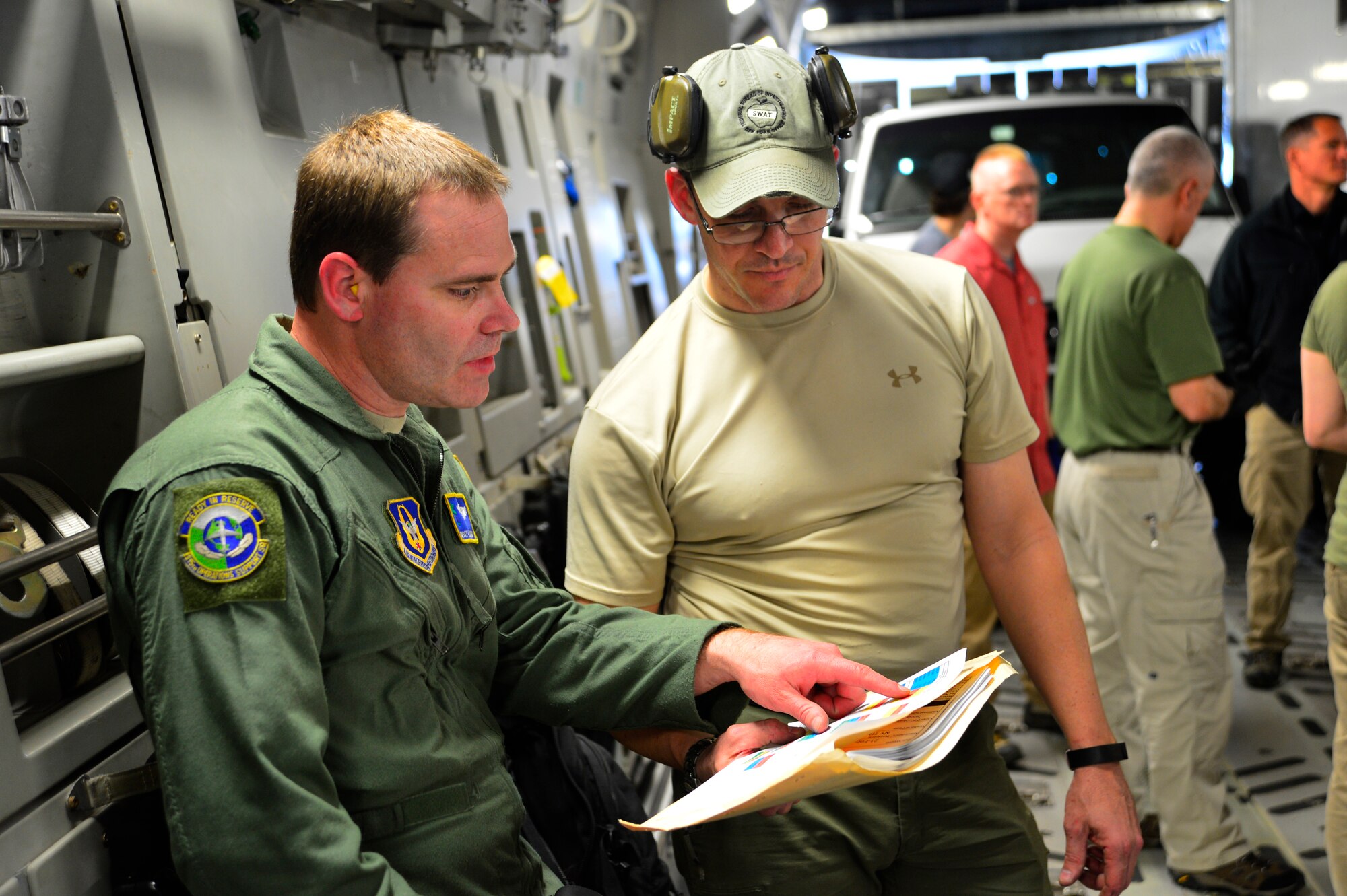 Senior Master Sgt. Howard Wiggs, 701st Airlift Squadron loadmaster, discusses the aircraft load with Scott Kerns, Federal Bureau of Investigation New York office special agent during Operation Patriot Sands, Feb. 21, 2014, at Homestead Air Reserve Base, Fla. Patriot Sands is a joint response exercise with Air Force and federal agencies including the FBI, FEMA and a Florida Advanced Surgical Transport Team, which simulates a national contingency event. (U.S. Air Force photo/Staff Sgt. Elizabeth Morris)