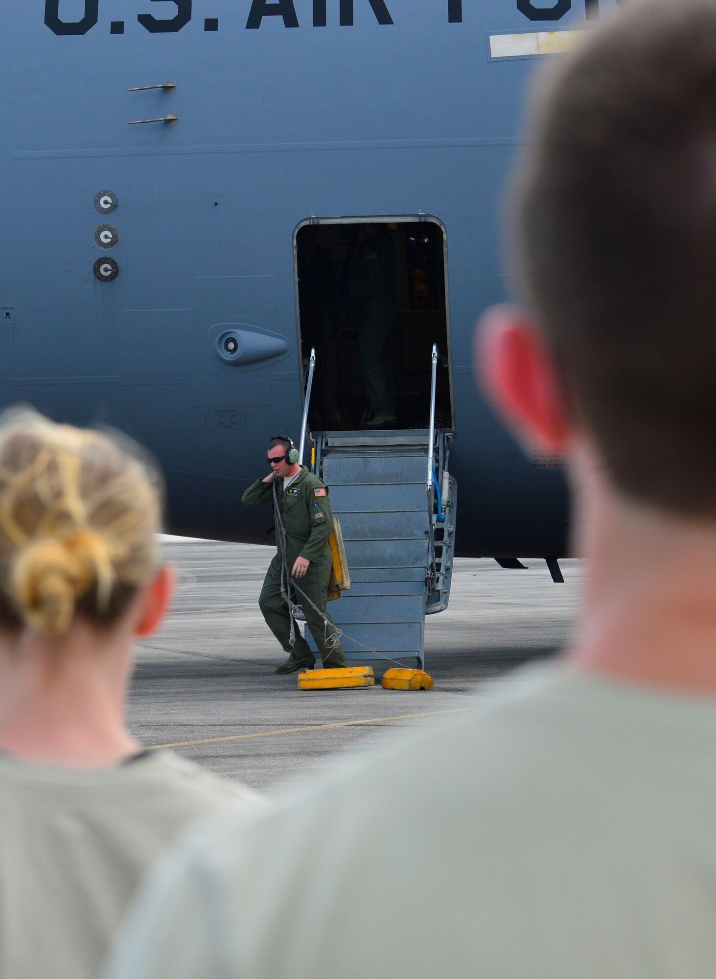 Airmen from the 46th Aerial Port Squadron stand by to unload cargo after a C-17 Globemaster III lands during Operations Patriot Sands, Feb. 21, 2014, at Homestead Air Reserve Base, Fla. Patriot Sands is a joint response exercise with Air Force and federal agencies that simulates a national contingency event. (U.S. Air Force photo/Staff Sgt. Elizabeth Morris)