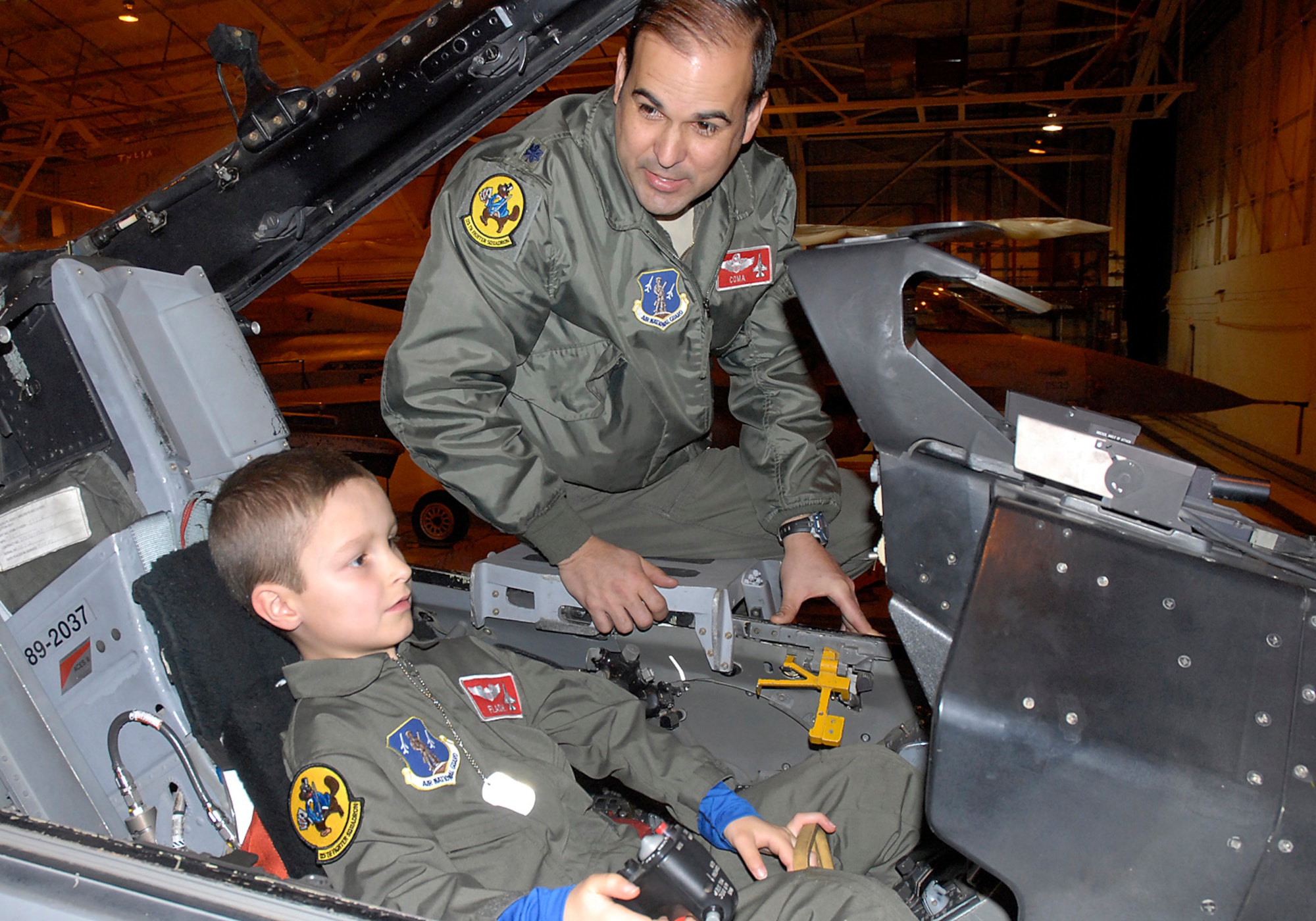 Lieutenant Colonel Ryan Jones, 138th Operation Support Squadron Commander, gives a cockpit orientation to Zip "Flash" Gordon, during his "Pilot for a Day" excursion, 19 February 2014,  at the 138th Fighter Wing, Oklahoma Air National Guard, Tulsa, Okla.   ( U.S. National Guard photo by Senior Airman Jasmine Stone/Released)