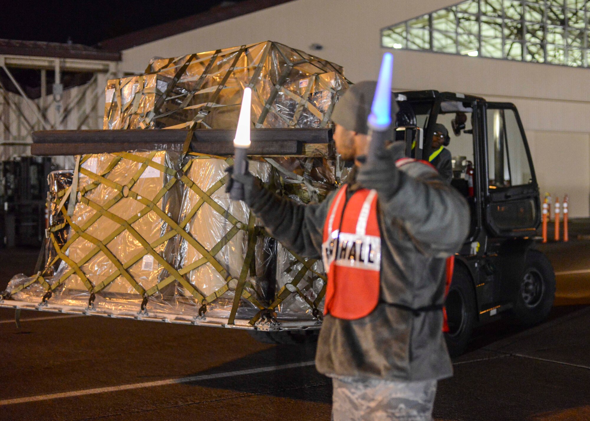 Airman 1st Class Stephen Royer, 374th Logistics Readiness Squadron vehicle maintainer directs a forklift to its destination during the Samurai Readiness Inspection at Yokota Air Base, Japan, March 4, 2014.  The 374th Airlift Wing will test its capability as the main airlift hub in the Pacific theater through the readiness inspection.  (U.S. Air Force photo by Airman 1st Class Soo C. Kim / released)