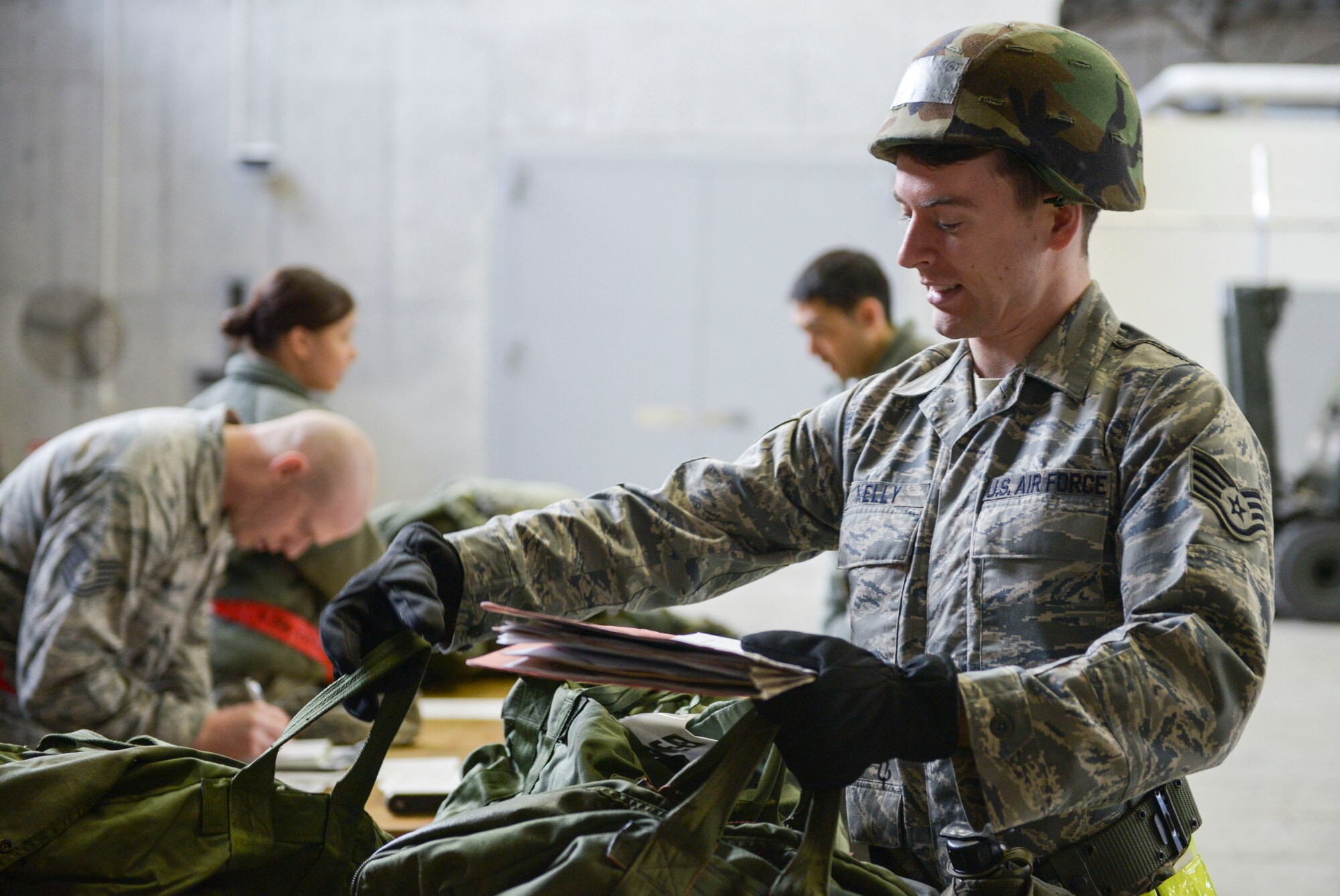 Staff Sgt. Zachary Kelly, 374th Operations Support Sqaurdon collects his bags during a Mission Oriented Protective Posture gear issue at Yokota Air Base, Japan, March 4, 2014. During a weeklong Samurai Readiness Inspection Yokota will evaluate its ability to perform and provide airlift capabilities through a variety of contingency response scenarios. (U.S. Air Force photo by Airman 1st Class David Danford/released)