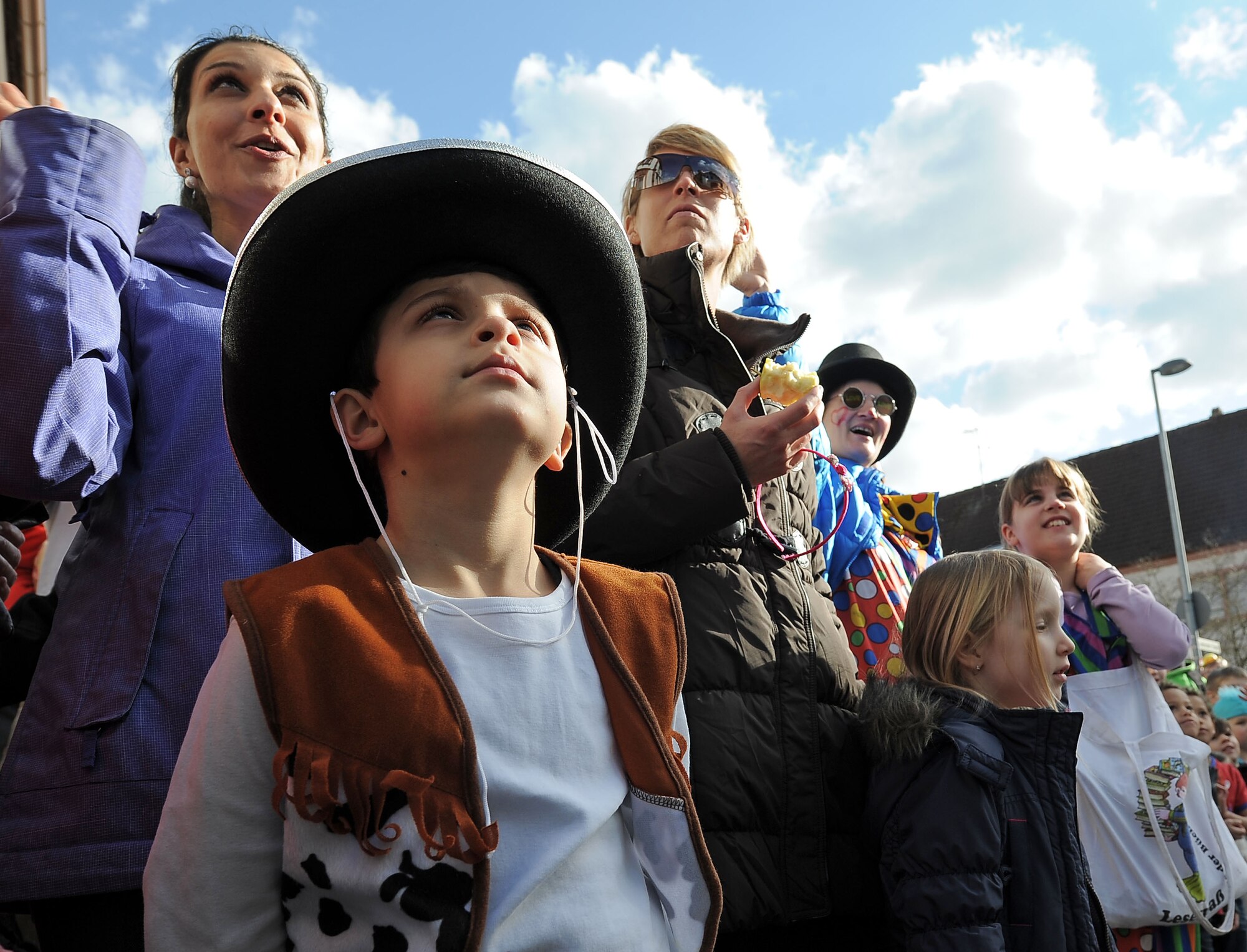 A child waits for parade participants to throw candy during the Fasching parade March 4, 2014, Ramstein Village, Germany. This annual event is a pre-Lenten carnival, which is celebrated with the donning of wild and fancy costumes to chase away the evil spirits of winter in preparation for spring. (U.S. Air Force photo/ Sara Pavich)