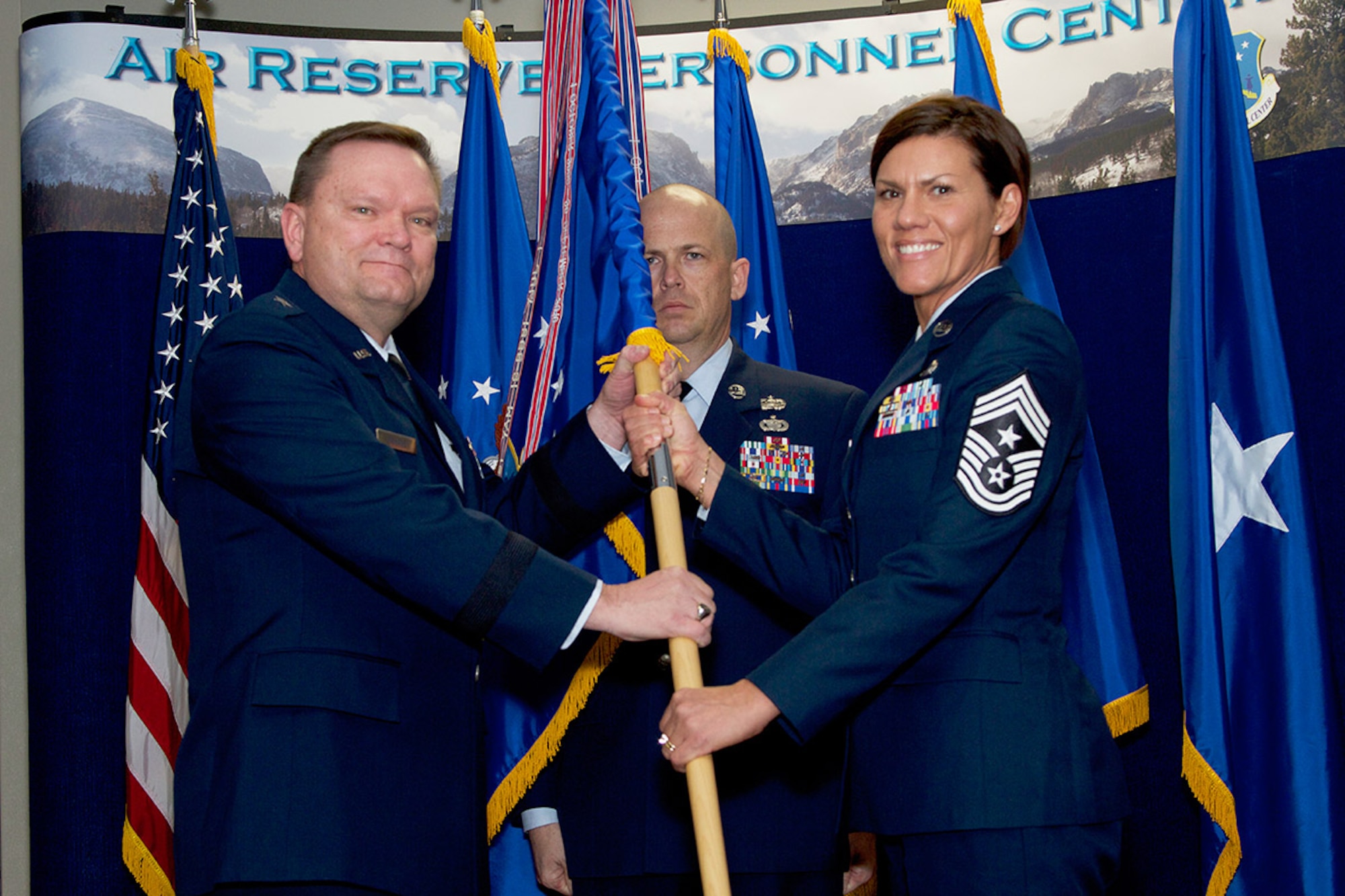 Brig. Gen. Samuel Mahaney, Air Reserve Personnel Center commander, hands the ARPC guidon to Chief Master Sgt. Ruth E. Flores, ARPC command chief, as Senior Master Sgt. John Neeley, ARPC first sergeant, stands by during an assumption of responsibility ceremony at Buckley Air Force Base, Aurora, Colo., Jan. 31, 2014. In December 2013 Chief Master Sgt. Ruth E. Flores became the Air Reserve Personnel Center’s first female command chief to represent the highest level of enlisted leadership here. As command chief, she is involved in advising the commander on all matters concerning the health, morale, welfare and effective utilization of more than 400 active duty, guardsmen, civilian employees and reserve enlisted members. (U.S. Air Force photo/Tech. Sgt. Mark Balli)