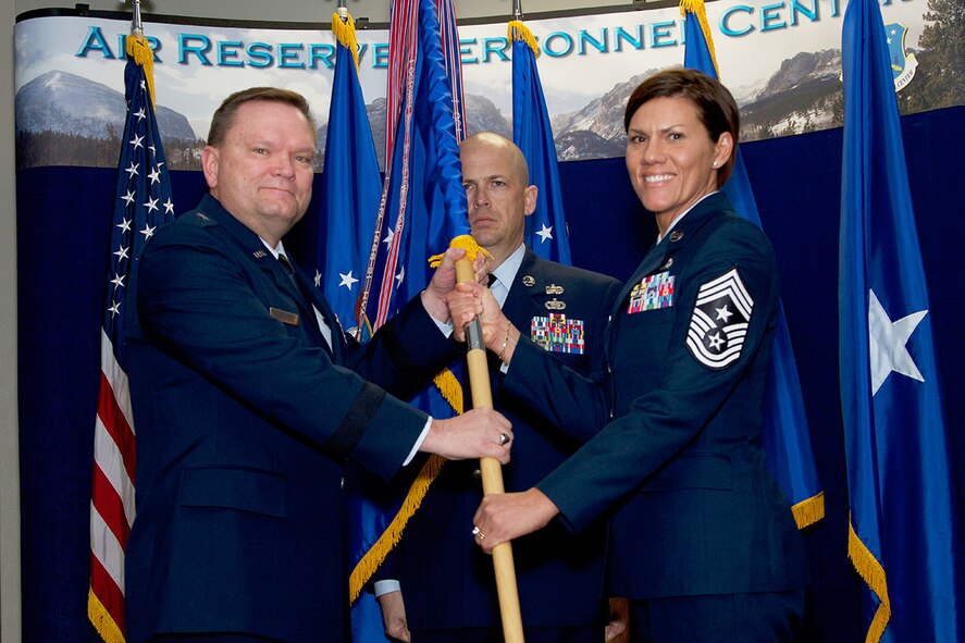 Brig. Gen. Samuel Mahaney, Air Reserve Personnel Center commander, hands the ARPC guidon to Chief Master Sgt. Ruth E. Flores, ARPC command chief, as Senior Master Sgt. John Neeley, ARPC first sergeant, stands by during an assumption of responsibility ceremony at Buckley Air Force Base, Aurora, Colo., Jan. 31, 2014. In December 2013 Chief Master Sgt. Ruth E. Flores became the Air Reserve Personnel Center’s first female command chief to represent the highest level of enlisted leadership here. As command chief, she is involved in advising the commander on all matters concerning the health, morale, welfare and effective utilization of more than 400 active duty, guardsmen, civilian employees and reserve enlisted members. (U.S. Air Force photo/Tech. Sgt. Mark Balli)