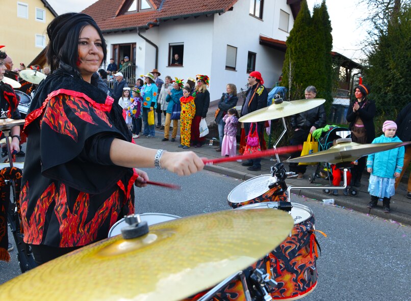 A women plays the drums during the Fasching parade March 4, 2014, Ramstein. This annual event is a pre-Lenten carnival, which is celebrated with the donning of wild and fancy costumes to chase away the evil spirits of winter in preparation for spring. (U.S. Air Force photo/Airman Dymekre Allen)