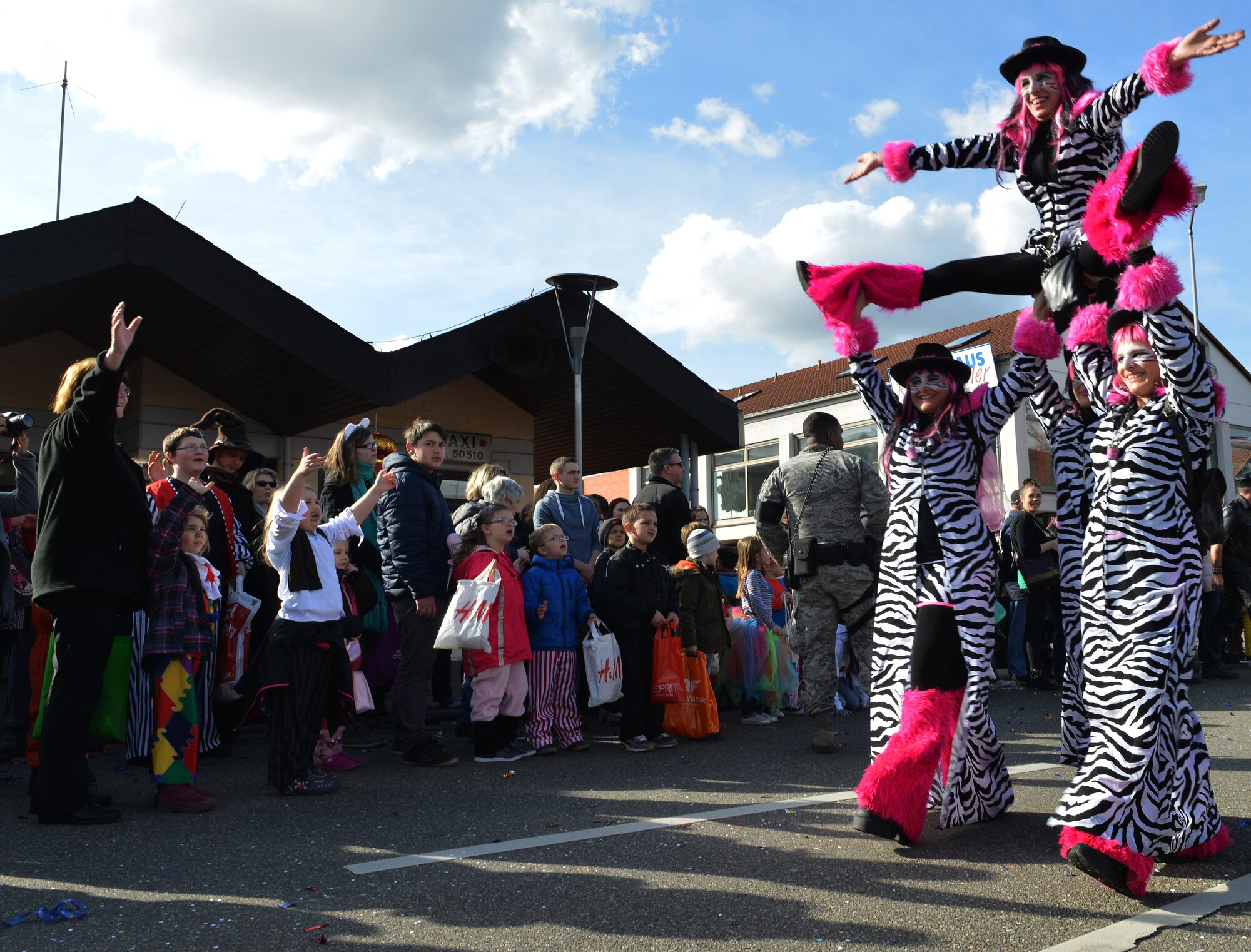 A dance team preforms stunts during the Fasching parade March 4, 2014, Ramstein Village, Germany. This annual event is a pre-Lenten carnival, which is celebrated with the donning of wild and fancy costumes to chase away the evil spirits of winter in preparation for spring. (U.S. Air Force photo/Airman Dymekre Allen)