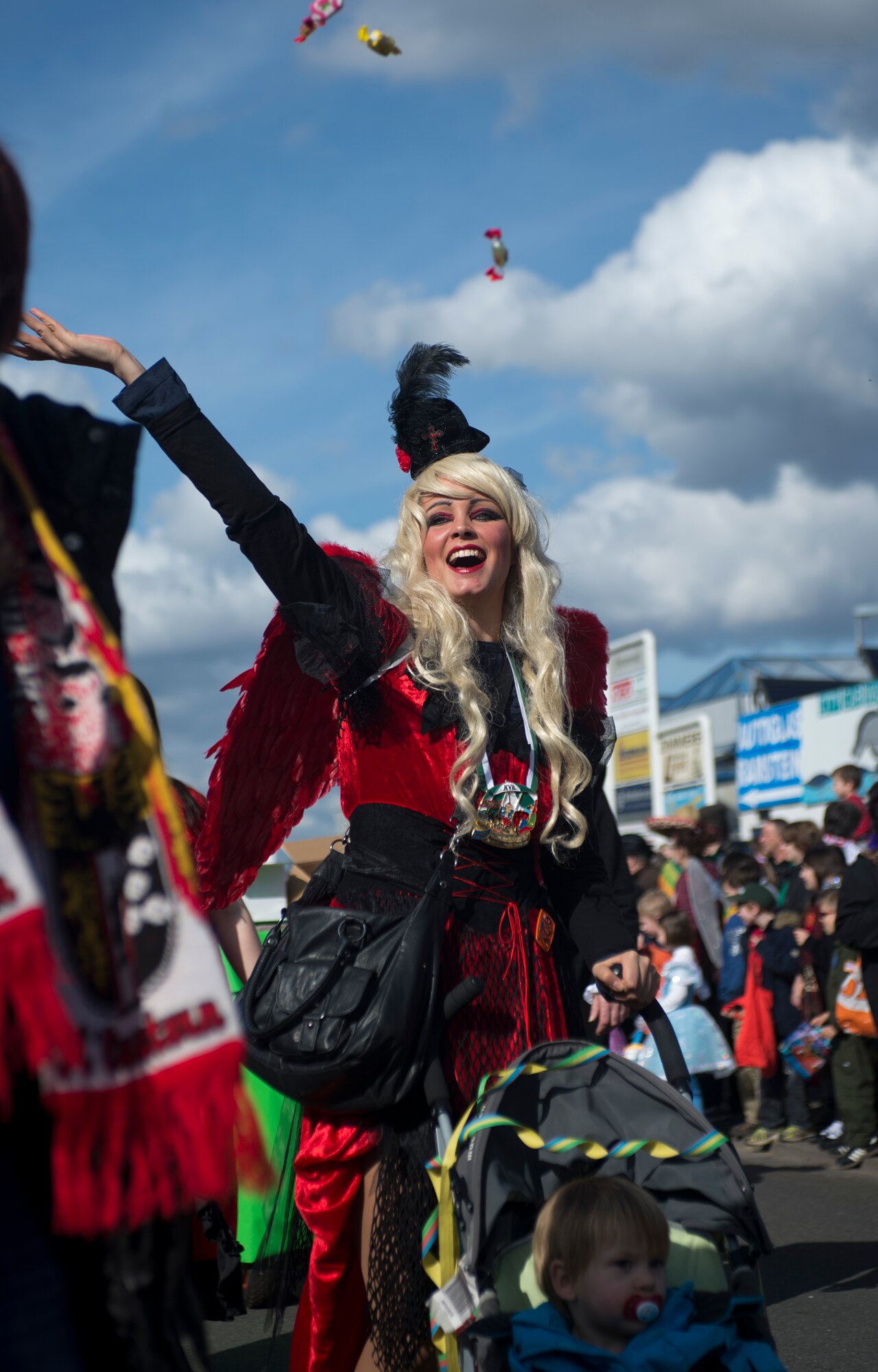 A Fasching parade reveler throws candies into the crowd, March 4, 2014, Ramstein Village, Germany. This annual event is a pre-Lenten carnival, which is celebrated with the donning of wild and fancy costumes to chase away the evil spirits of winter in preparation for spring. (U.S. Air Force photo/Airman 1st Class Jordan Castelan)