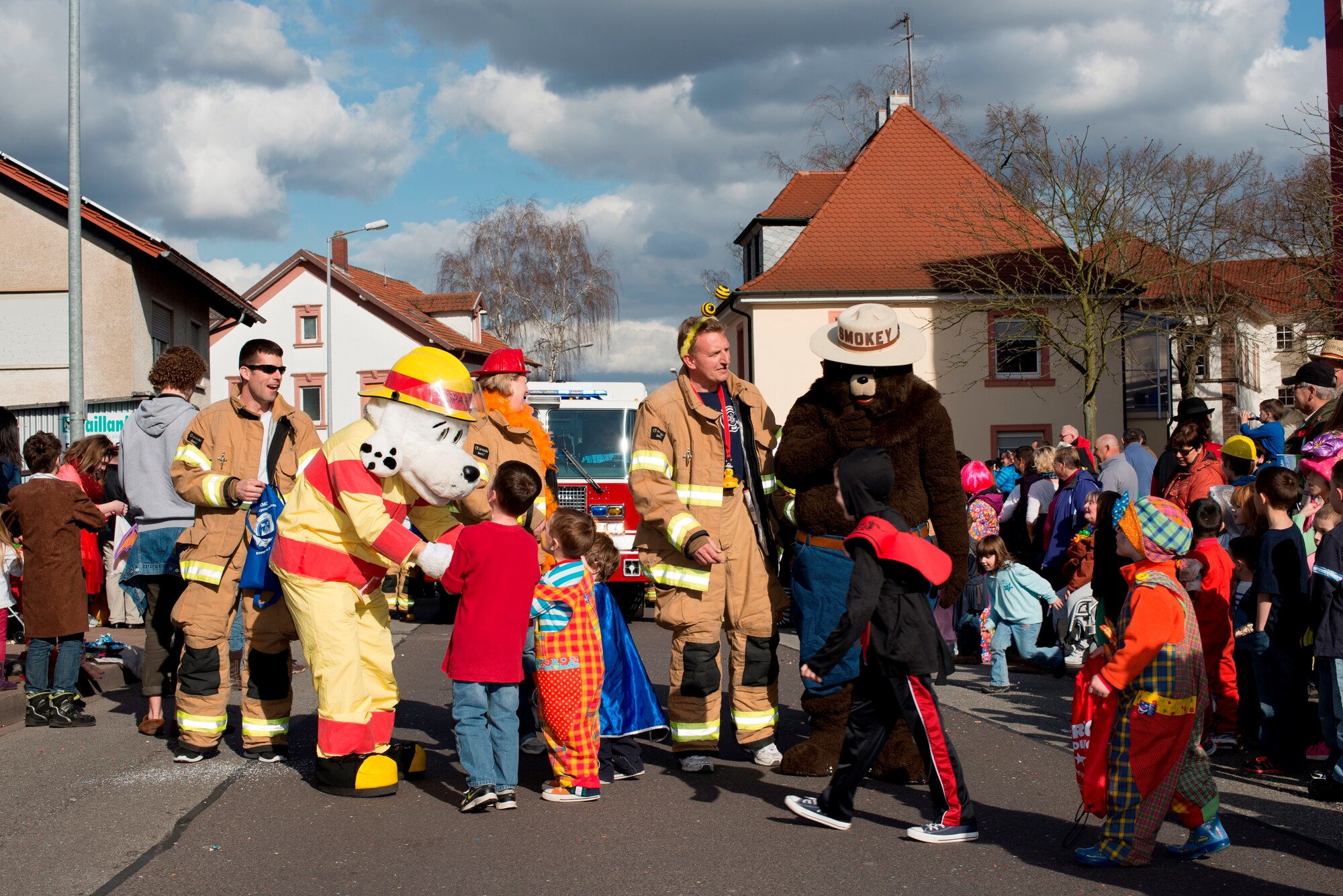 Sparky the Fire Safety Dog and Smokey the Bear dance with children during the annual Fasching parade, March 4, 2014, Ramstein Village, Germany. This annual event is a pre-Lenten carnival, which is celebrated with the donning of wild and fancy costumes to chase away the evil spirits of winter in preparation for spring. (U.S. Air Force Photo/Senior Airman Jose L. Leon)