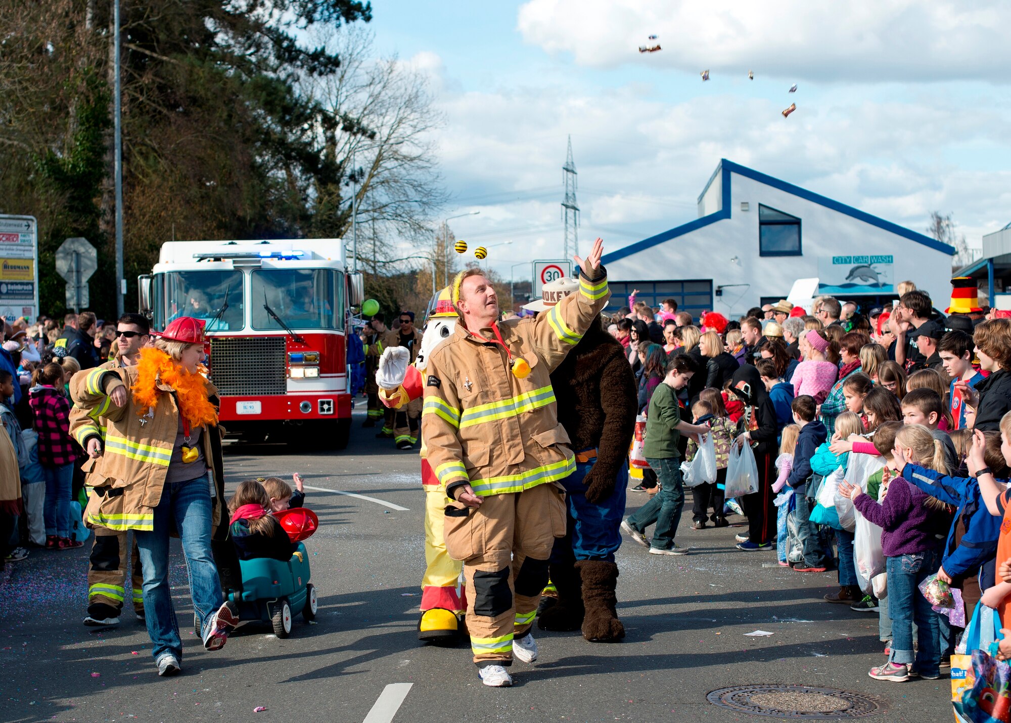 Firefighters from Ramstein Air Base toss candy to children during the annual Fasching parade, March 4, 2014, Ramstein Village, Germany. This annual event is a pre-Lenten carnival, which is celebrated with the donning of wild and fancy costumes to chase away the evil spirits of winter in preparation for spring. (U.S. Air Force Photo/Senior Airman Jose L. Leon)