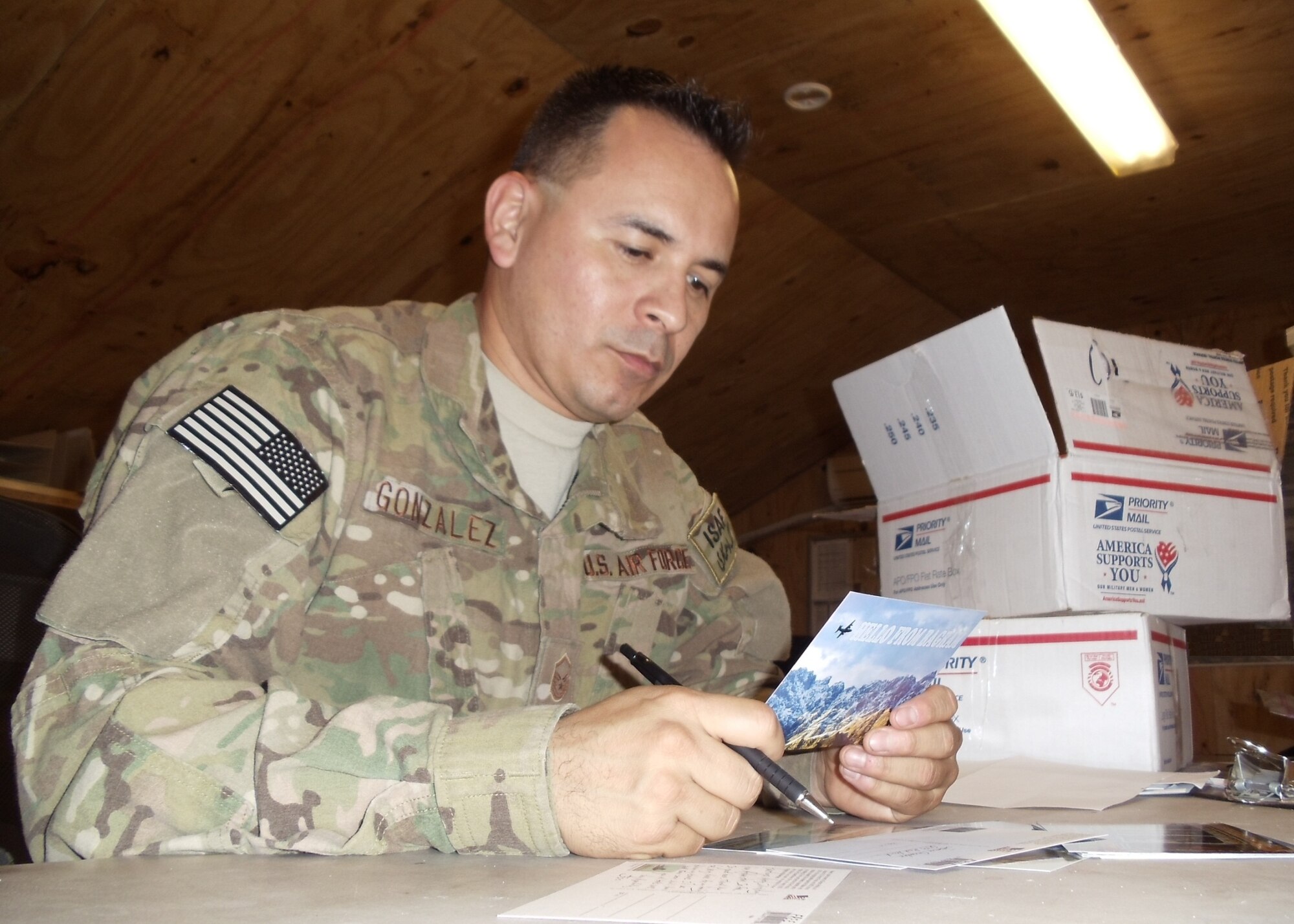 Then MSgt Jose M. Gonzalez prepares a postcard to a Tucson, AZ Veterans of Foreign Wars chapter in appreciation to recent care packages his unit received.           