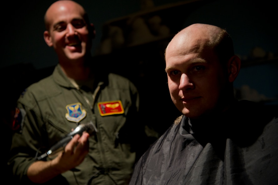 Air crew members from the 23rd Bomb Squadron shave their heads to support Brayden Mitchell, who has diagnosed with a stage three Wilms tumor, a form of kidney cancer. Capt. Michael DeVita, 23rd BS B-52 instructor pilot, is a friend of the Mitchell family. (U.S. Air Force photo/Senior Airman Brittany Y. Auld)