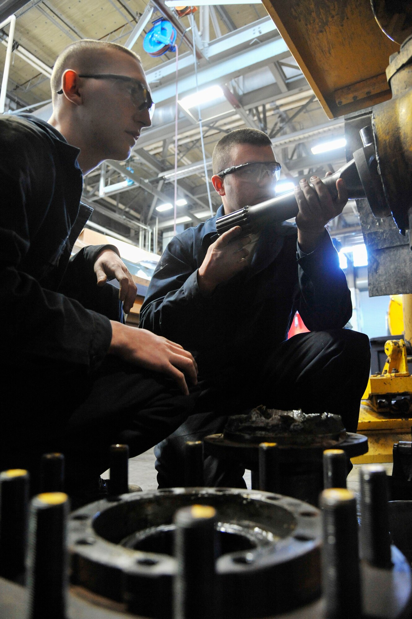 U.S. Air Force Air Force Airman 1st Class Cody Smith, 509th Logistics Readiness Squadron vehicle maintenance journeyman, left, and Staff Sgt. Kyle Bemis, 509th Logistics Readiness Squadron vehicle maintenance craftsman, remove broken axle shot at Whiteman Air Force Base, Mo., Feb. 21, 2014. The axle shot works with the differential to help the vehicle to move. (U.S. Air Force photo by Airman 1st Class Keenan Berry/Released)