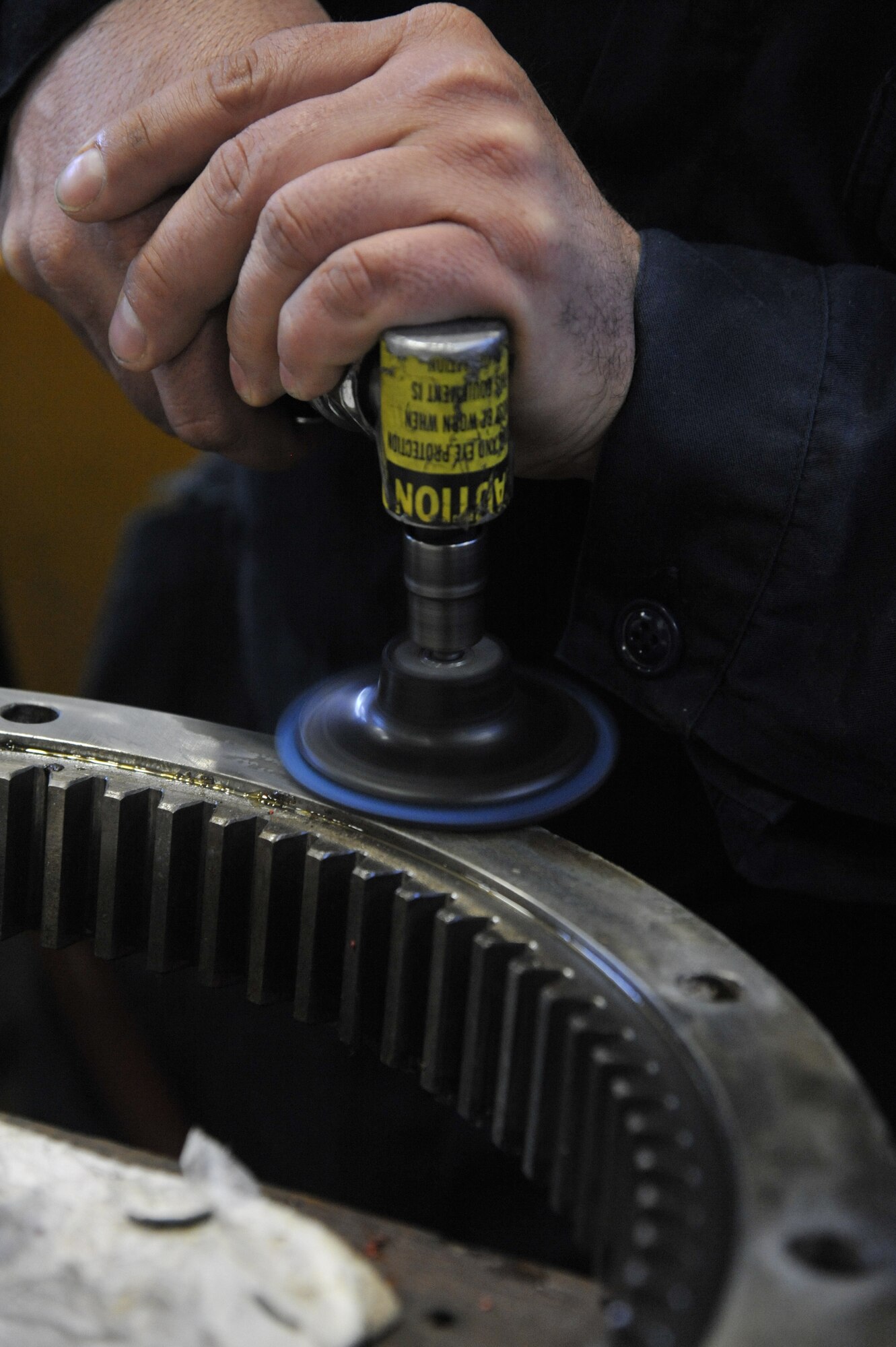 U.S. Air Force Tech Sgt. Dan Early, 509th Logistics Readiness Squadron NCO in charge of high bay, uses an abrasive wheel to clean a sun gear at Whiteman Air Force Base, Mo., Feb. 21, 2014. This tool is used to clean the surface and ensure the seals are flush. (U.S. Air Force photo by Airman 1st Class Keenan Berry/Released)