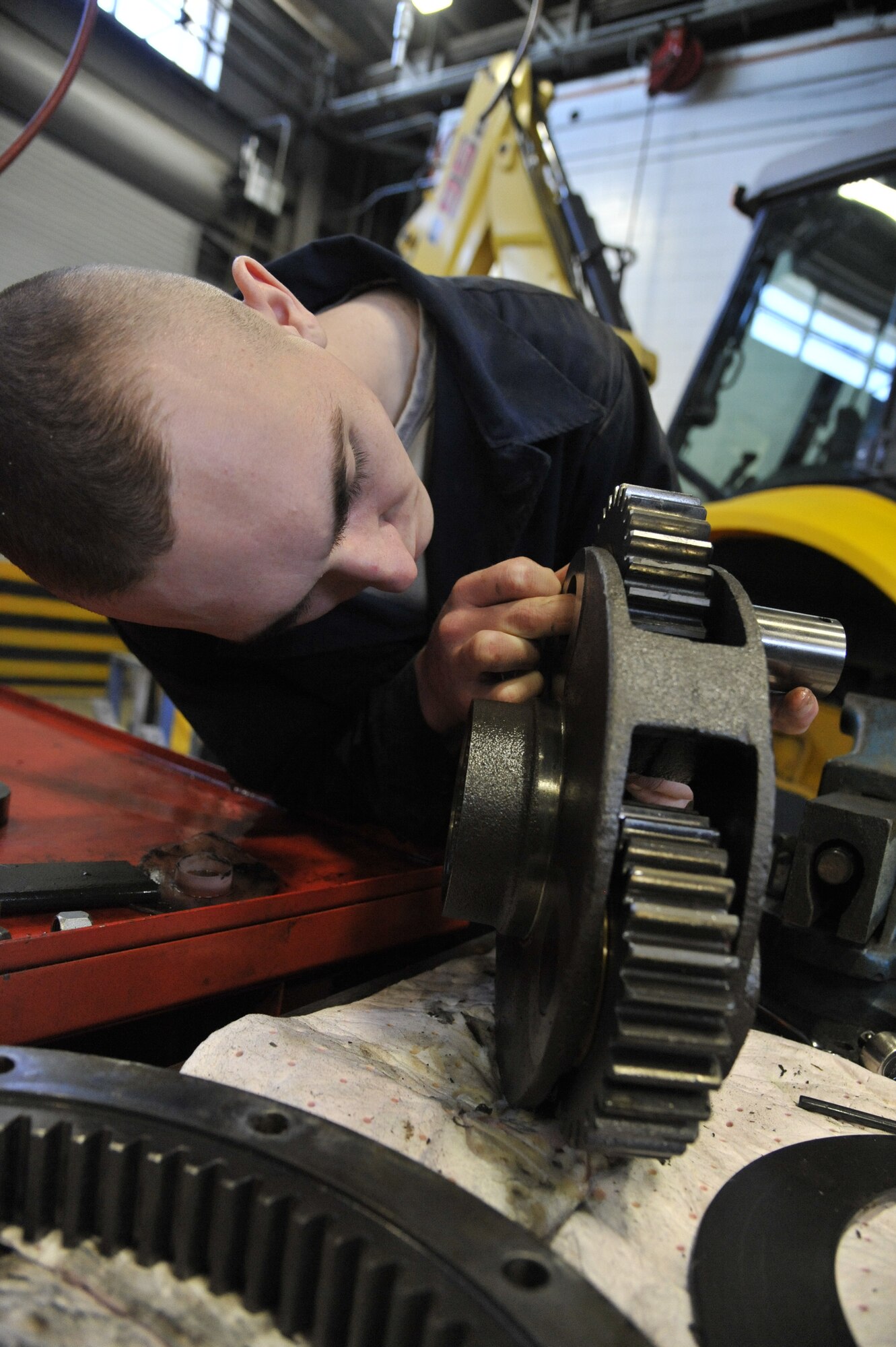 U.S. Air Force Airman 1st Class Cody Smith, 509th Logistics Readiness Squadron vehicle maintenance journeyman, installs a planetary gear on a 30-ton crane winch at Whiteman Air Force Base, Mo., Feb. 21, 2014. The planetary gear allows the crane to lift loads. If the gear is not properly installed, the crane will lock up, preventing lifting.  (U.S. Air Force photo by Airman 1st Class Keenan Berry/Released)