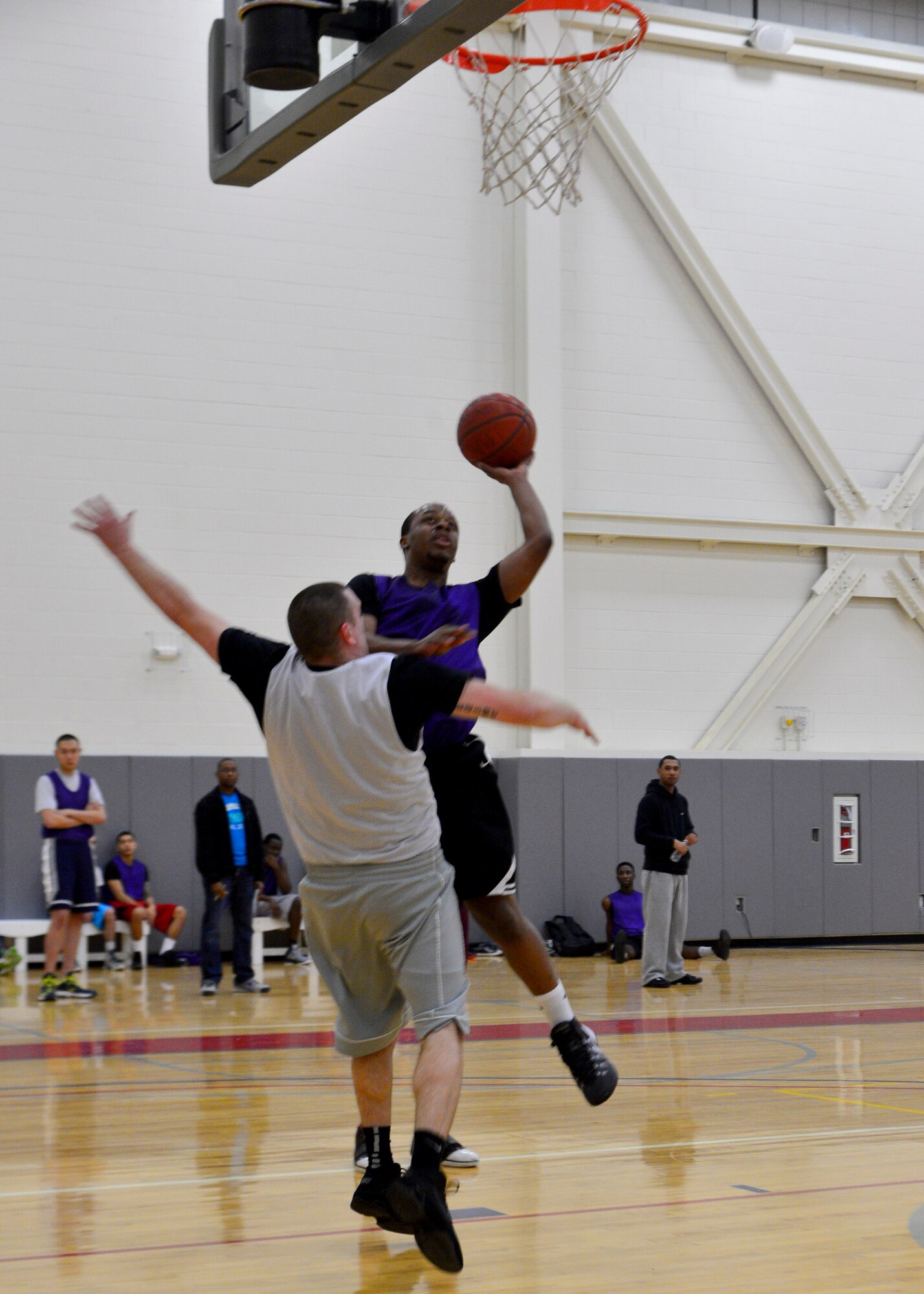 Kenny Roberts, 436th Aerial Port Squadron guard, drives for a layup as Andrew Draime, 436th Maintenance Squadron guard, defends during an intramural basketball game Feb. 27, 2014, at the fitness center on Dover Air Force Base, Del. Roberts scored 12 points in the second to help lead his team to the 49-34 victory. (U.S. Air Force photo/Airman 1st Class Zachary Cacicia)