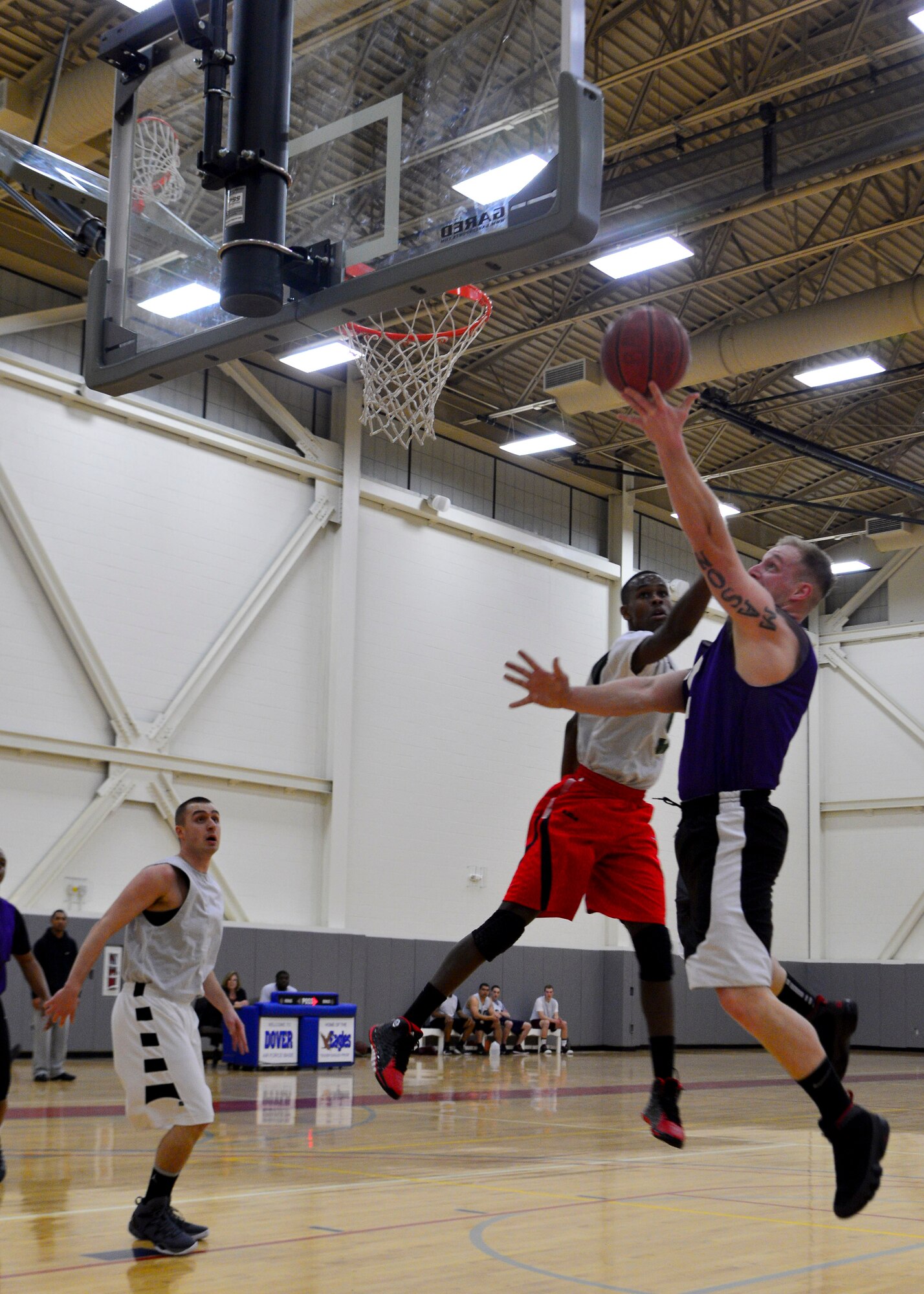 Lucas Evans, 436th Aerial Port Squadron guard, drives for a layup as Ricco Jones, 436th Maintenance Squadron guard, defends during an intramural basketball game Feb. 27, 2014, at the fitness center on Dover Air Force Base, Del. The 436th APS rallied from a three-point deficit at halftime to win the game 49-34. (U.S. Air Force photo/Airman 1st Class Zachary Cacicia)