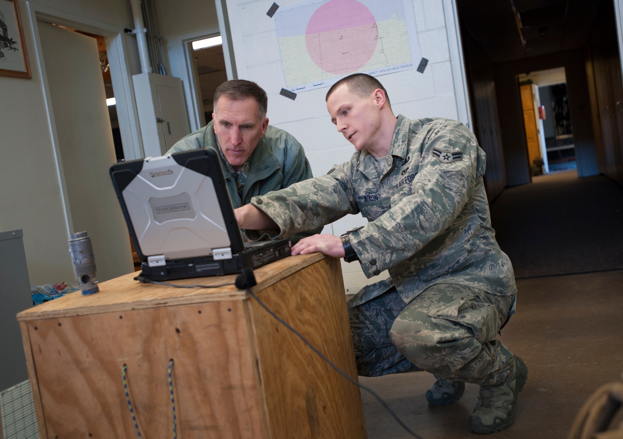 Maj. Gen. Scott Vander Hamm, Eighth Air Force commander, is briefed on an explosive ordnance disposal computer system at Minot Air Force Base, N.D., Feb. 25, 2014. Vander Hamm visited the EOD unit, along with many other 5th Bomb Wing squadrons on his first visit as 8th AF commander. (U.S. Air Force photo/Airman 1st Class Apryl Hall)