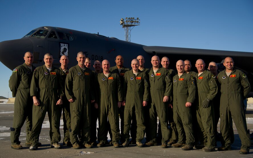 Members of the 23rd Bomb Squadron pose for a group photo with clean-shaven heads for Brayden Mitchell, who has diagnosed with a stage three Wilms tumor, a form of kidney cancer. Capt. Michael DeVita, 23rd BS B-52 instructor pilot, is a friend of the Mitchell family. (U.S. Air Force photo/Senior Airman Brittany Y. Auld)