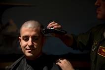 Capt. Michael DeVita, 23rd Bomb Squadron B-52H Stratofortress instructor pilot gets his head shaved at Minot Air Force Base, N.D., Feb. 21, 2014. DeVita and 16 members of the 23rd BS shaved their heads in support of a 5-year-old cancer patient. (U.S. Air Force photo/Senior Airman Brittany Y. Auld)