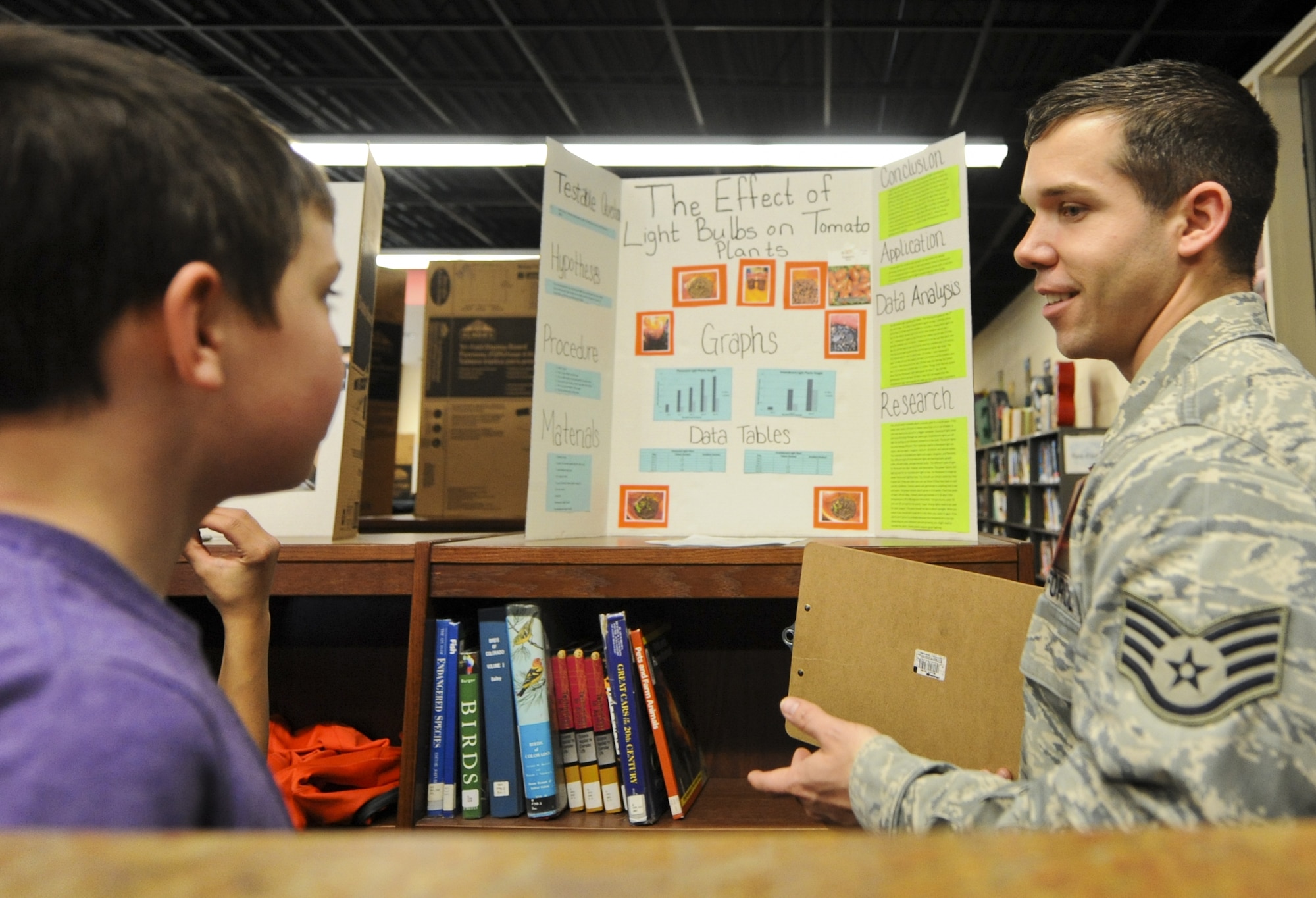 COLORADO SPRINGS, Colo. – Staff Sgt. Justin Dillinger, 721st Communications Squadron, speaks with a student at a science fair Feb. 24 at North Middle School in Colorado Springs, Colo.  Dillinger volunteered at the school and graded several different projects, engaging the students in different methods to approach their topics. (U.S. Air Force photo/Staff Sgt. Jacob Morgan)