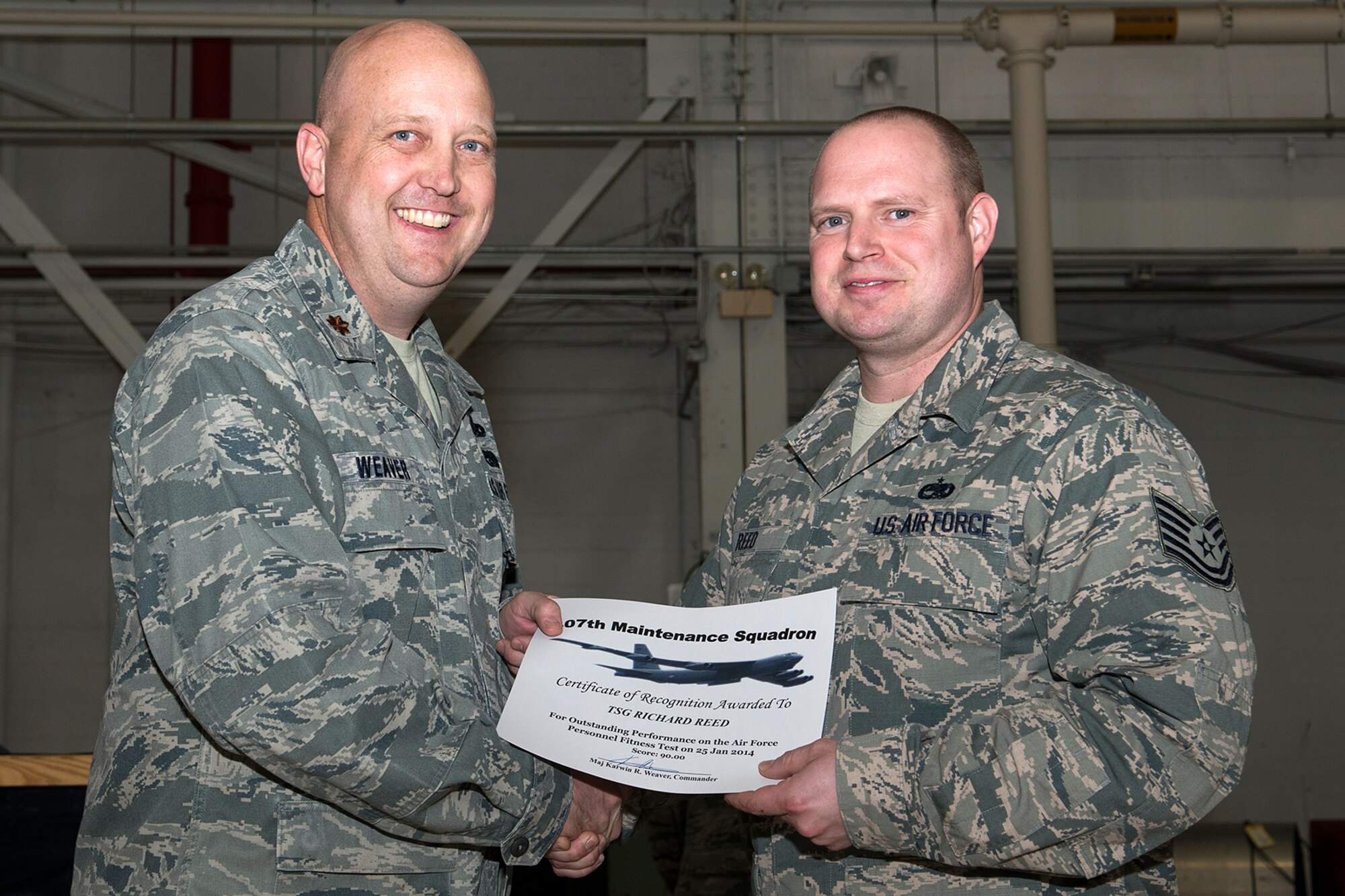 U.S. Air Force Maj. Karwin Weaver, 307th Maintenance Squadron commander, presents a Certificate of Recognition to Tech. Sgt. Richard Reed, Mar. 1, 2014, Barksdale Air Force Base, La. Reed received the certificate for scoring over 90 percent or over on the Air Force Personnel Fitness Test. (U.S. Air Force photo by Master Sgt. Greg Steele/Released)