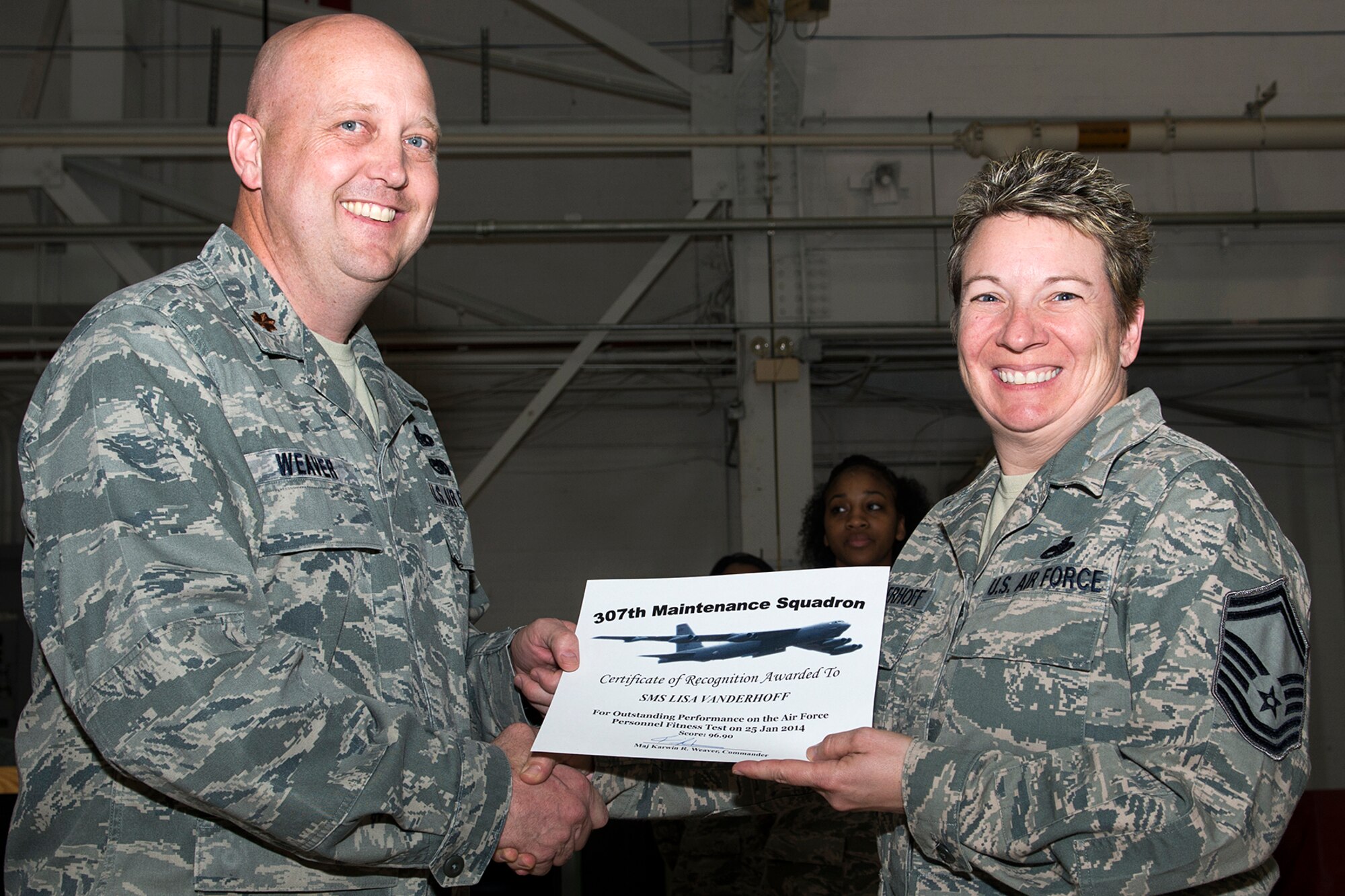 U.S. Air Force Maj. Karwin Weaver, 307th Maintenance Squadron commander, presents a Certificate of Recognition to Senior Master Sgt. Lisa Vanderhoff, Mar. 1, 2014, Barksdale Air Force Base, La. Vanderhoff received the certificate for scoring over 90 percent or over on the Air Force Personnel Fitness Test. (U.S. Air Force photo by Master Sgt. Greg Steele/Released)