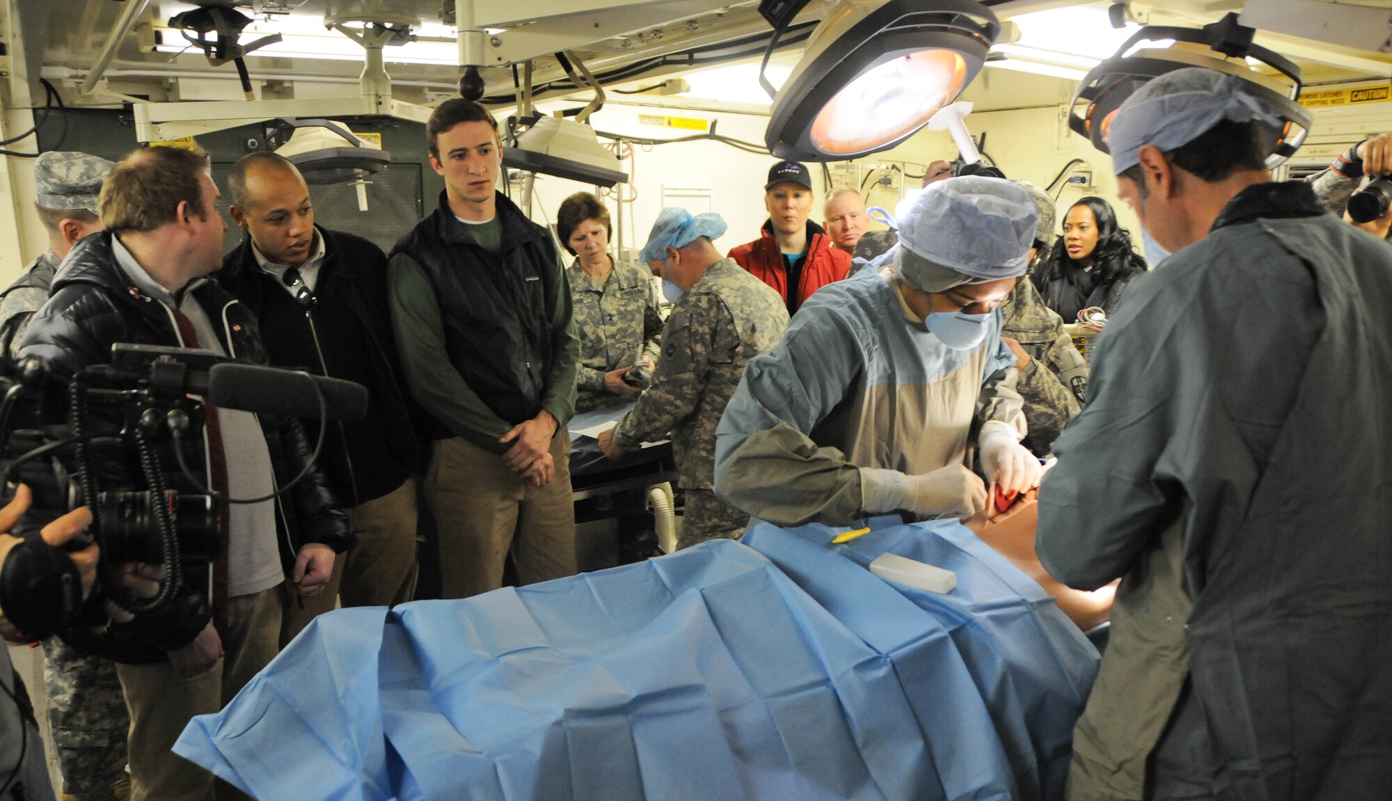 Congressional staff members and military leaders observe surgical training Feb. 24 during a tour of the Global Medic portion of the joint Combat Support Training Exercise hosted by the Army Reserve's 78th Training Division at Joint Base McGuire-Dix-Lakehurst, N.J. This training event was focused on the Human-Worn Partial-Task Surgical Simulator, also known as a "cut suit," which represents a realistic way to simulate the look, feel and smell effects of a traumatic injury while allowing physicians to safely perform real procedures on a live person. The staff-delegation tour was designed to highlight the Army Reserve's capabilities as an operational force and the importance of maintaining these capabilities into the future. (U.S. Army photo by Staff Sgt. Shawn Morris/Released)