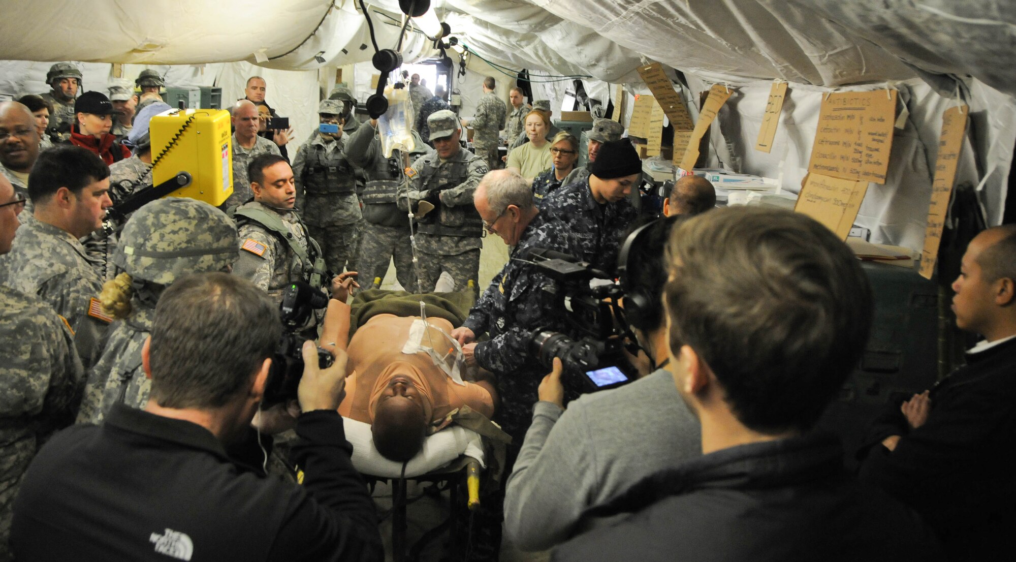 Congressional staff members and military leaders observe surgical training Feb. 24 during a tour of the Global Medic portion of the joint Combat Support Training Exercise hosted by the Army Reserve's 78th Training Division at Joint Base McGuire-Dix-Lakehurst, N.J. This training event was focused on the Human-Worn Partial-Task Surgical Simulator, also known as a "cut suit," which represents a realistic way to simulate the look, feel and smell effects of a traumatic injury while allowing physicians to safely perform real procedures on a live person. The staff-delegation tour was designed to highlight the Army Reserve's capabilities as an operational force and the importance of maintaining these capabilities into the future. (U.S. Army photo by Staff Sgt. Shawn Morris/Released)