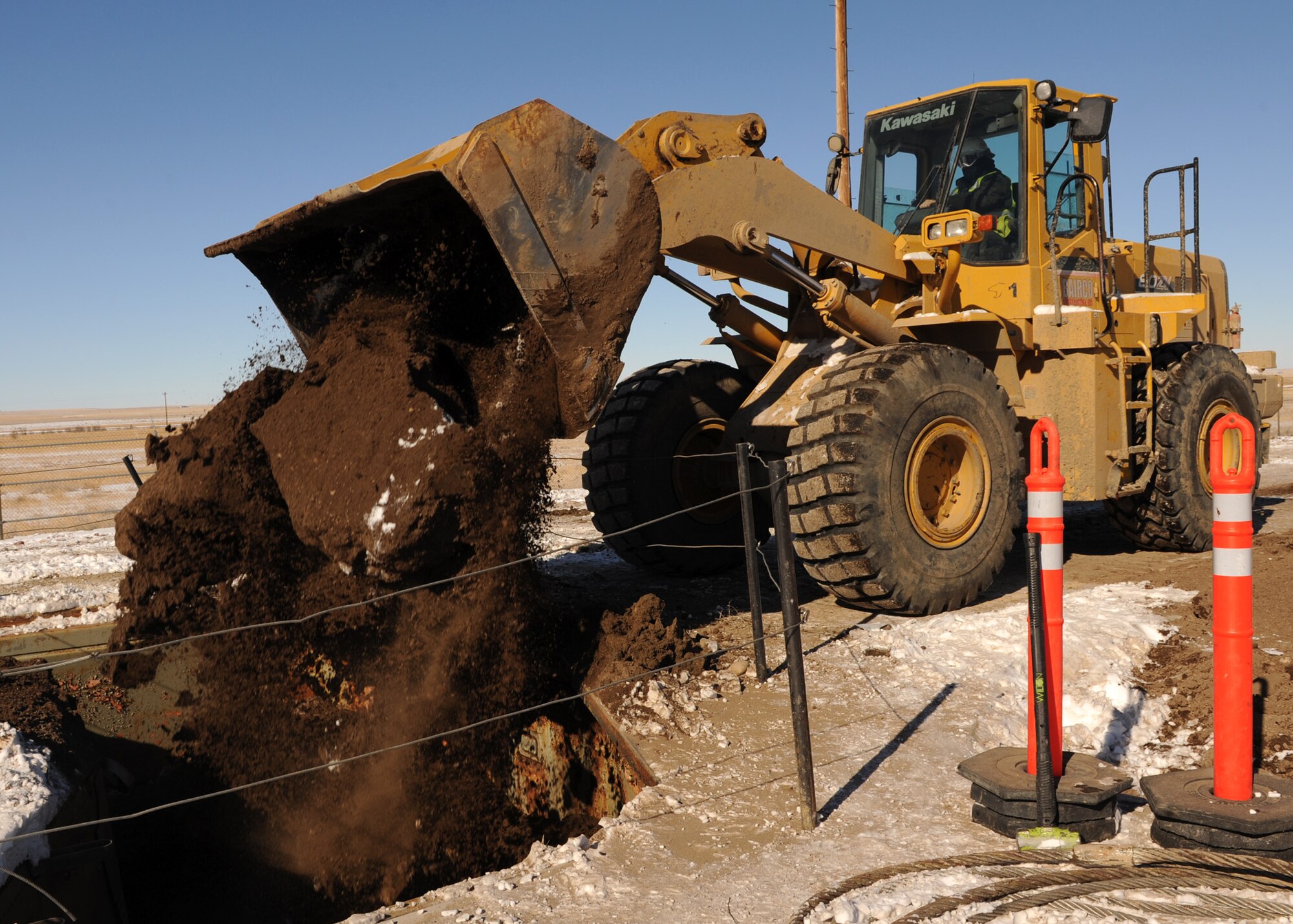 A construction worker fills earth and gravel into the launcher tube at Launch Facility R-29, Pondera County, Mont., on Feb. 25. To meet the New Strategic Arms Reduction Treaty requirements, 50 previously deactivated 564th Missile Squadron Minuteman III launch facilities are being permanently eliminated. The deactivation process involved the removal of ICBM’s from the facilities, and since that time the silos have remained in caretaker status. (U.S. Air Force photo/Senior Airman Katrina Heikkinen)