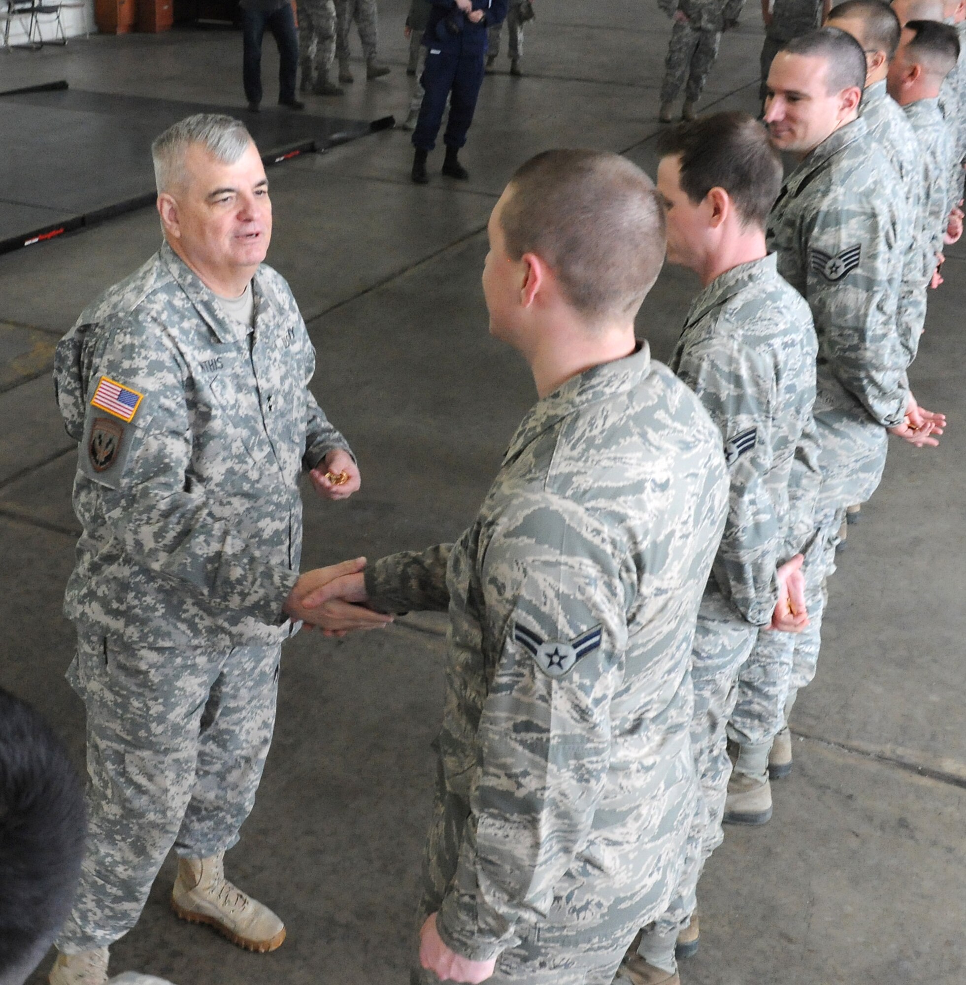 U.S. Army Maj. Gen. Jeff W. Mathis III, commander, Joint Task Force Civil Support, presents coins to airmen of the 633rd Logistics Readiness Squadron during his visit to to Joint Base Langley-Eustis, Va., Feb. 26, 2014.  Mathis presented commander coins to show his appreciation to the squadron for providing assistance during a recent JTF-CS no-notice deployment readiness exercise (DRE). Internal exercises, such as DREs, ensure the unit's preparedness to support local first responders in the event of a man-made or a natural disaster in the United States. JTF-CS anticipates, plans, and prepares for Chemical, Biological, Radiological, and Nuclear Defense Support of Civil Authorities (CBRN-DSCA) response operations. (DOD photo by U.S. Navy Petty Officer 1st Class Brian Dietrick/Released)