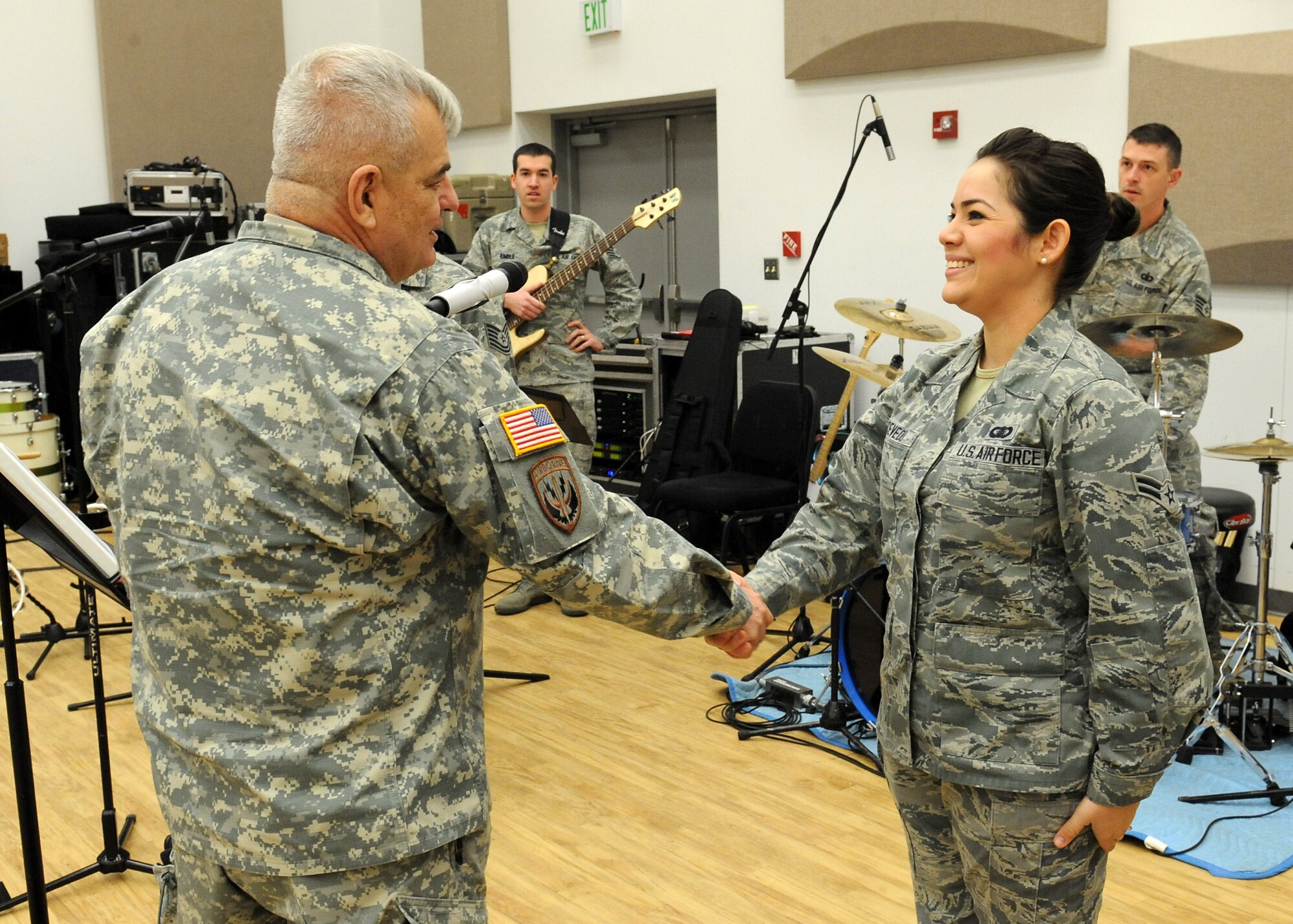 U.S. Army Maj. Gen. Jeff W. Mathis III, commander, Joint Task Force Civil Support, presents a commander's coin to U.S. Air Force Senior Airman Mara Acevedo, Full Spectrum band member, during his visit to Joint Base Langley-Eustis, Va., Feb. 26, 2014. Full Spectrum is part of the U.S. Air Force Heritage of America band and Mathis presented commander coins to show his appreciation to the band for providing the musical entertainment at the recent JTF-CS Burns Night Dining Out, and to Acevedo for singing the national anthem.  JTF-CS anticipates, plans, and prepares for Chemical, Biological, Radiological, and Nuclear Defense Support of Civil Authorities (CBRN-DSCA) response operations. (DOD photo by U.S. Navy Petty Officer 1st Class Brian Dietrick/Released)