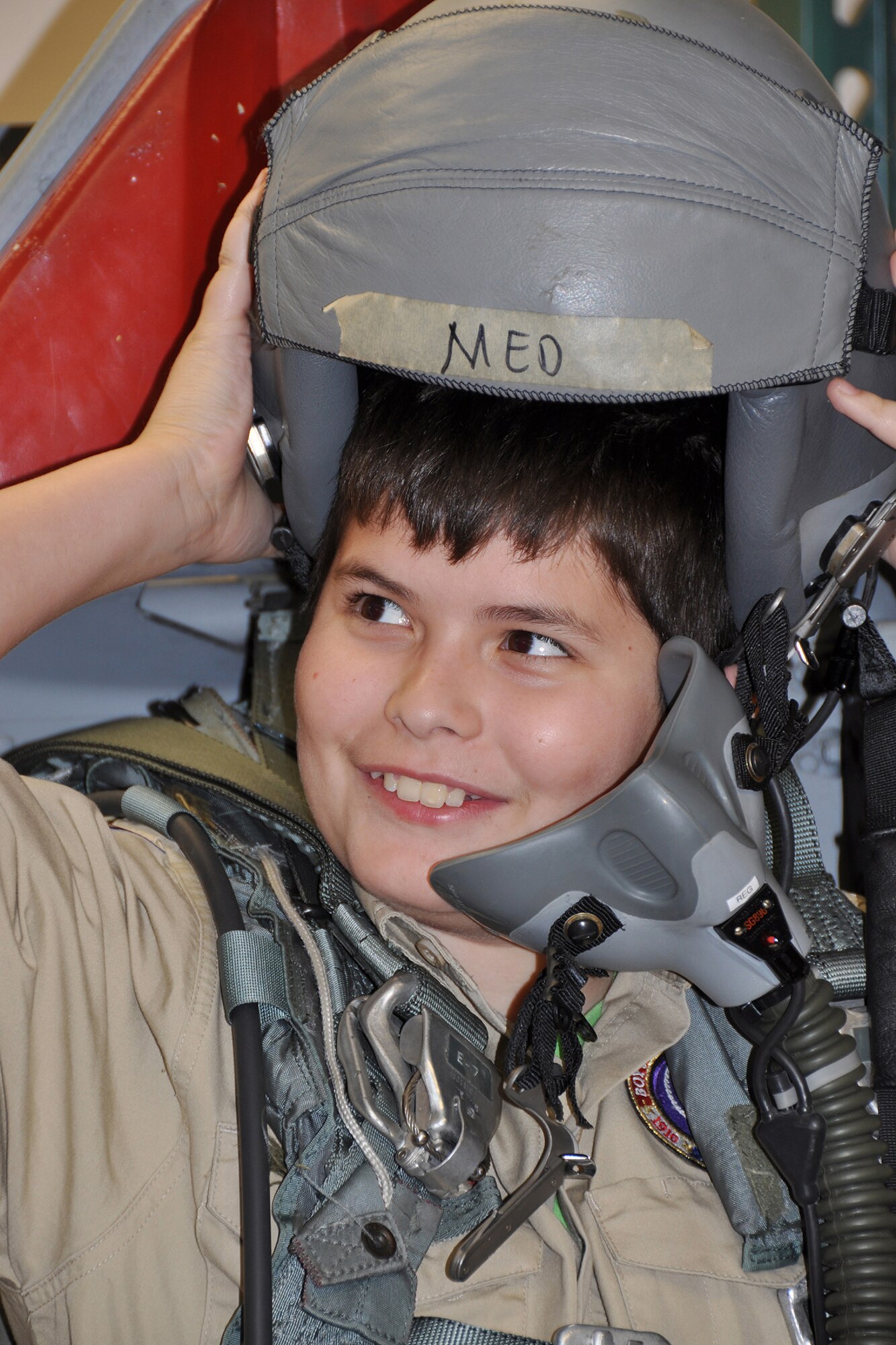 A boy scout with Troop 531 out of Angleton, Texas, is all smiles as he prepares to try on a helmet at the 307th Bomb Wing Life Support March 1, 2014. The Troop visited Barksdale Air Force Base, La., for an orientation tour including visits to the munitions storage area, engine shop, B-52 static display and Global Power Museum.  (U.S. Air Force photo by Master Sgt. Mary Hinson/Released)