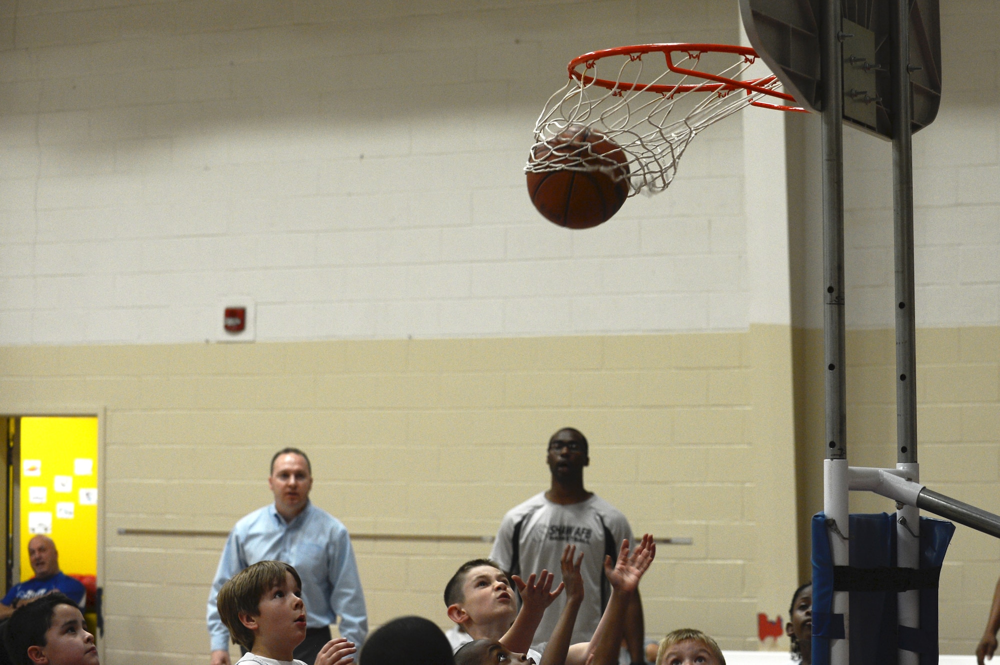 Teams and coaches watch as a basketball scores during a Playoff game at the Youth Center on Shaw Air Force Base, S.C., Feb. 25, 2014. The youth sports program’s goals are that children learn teamwork, discipline, sportsmanship, respect, develop physically, and mature emotionally and socially. (U.S. Air Force photo by Airman 1st Class Diana M. Cossaboom/Released)