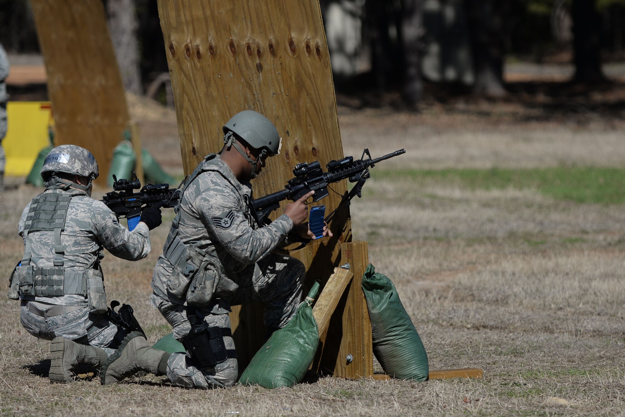 U.S. Air Force Staff. Sgt. Garrett Cole, 20th Security Forces Squadron security forces patrolman, (right), reloads his weapon behind a wooden barricade while Airman 1st Class Mario Soriano, 20th SFS security forces specialist, provides cover support at Shaw Air Force Base, S.C., Feb. 28, 2014. Cole and Soriano were one of many different fire teams that participated in the shoot, move, and communicate training exercise. (U.S. Air Force photo by Airman 1st Class Michael A. Cossaboom/Released)