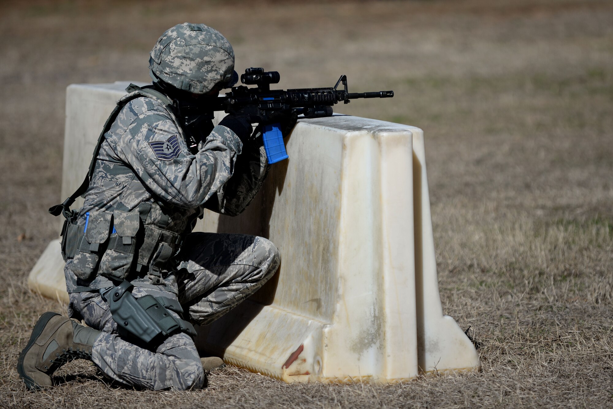U.S. Air Force Tech. Sgt. Michael Ambriz, 20th Security Forces Squadron flight chief, kneels to cover his advancing fire-team member during a squadron shoot, move, and communicate training at Shaw Air Force Base, S.C., Feb. 28, 2014. The training was held to sharpen the Airmen’s ability to perform on the battlefield and ensure they have the knowledge to be successful. (U.S. Air Force photo by Airman 1st Class Michael A. Cossaboom/Released) 