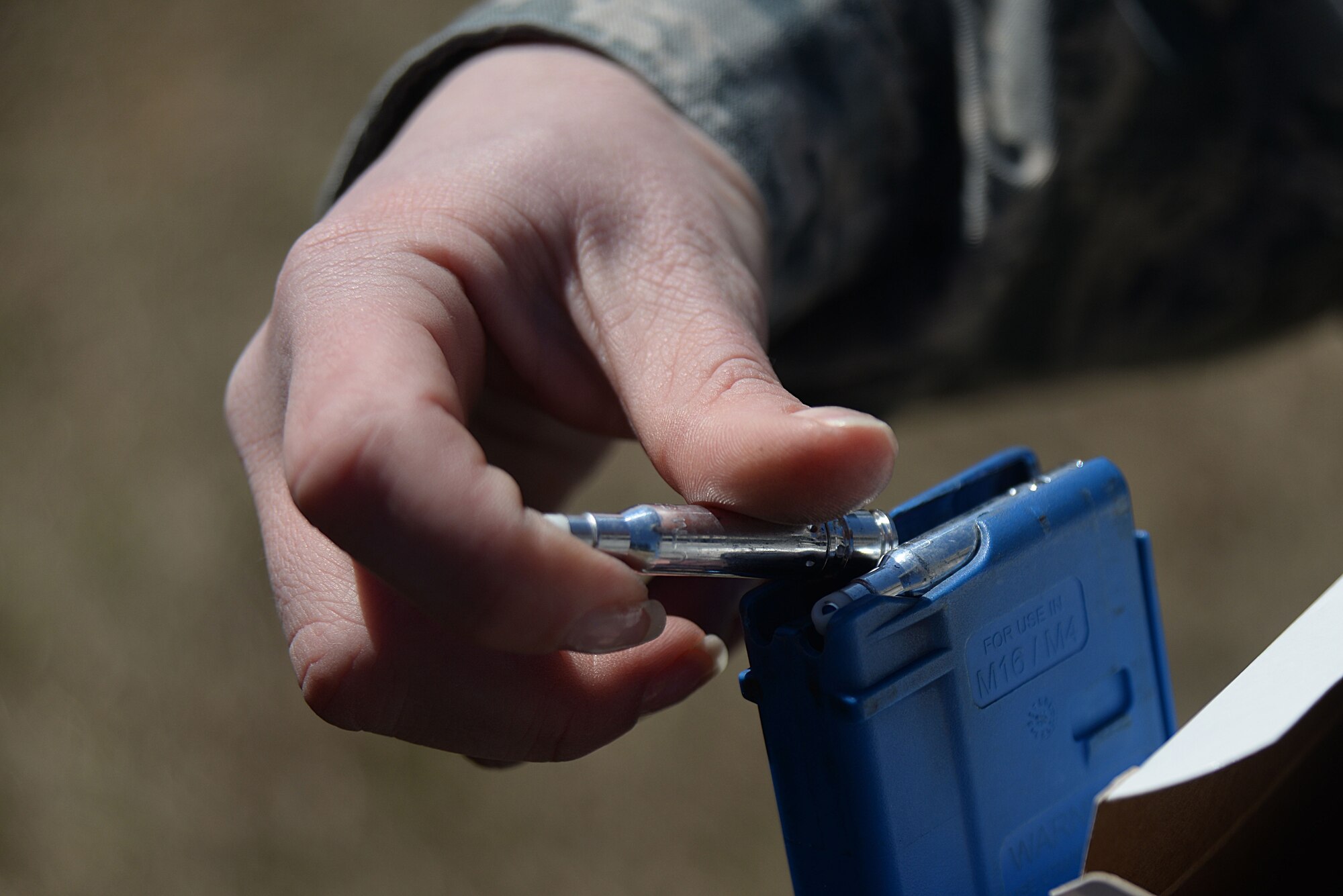 A U.S. Air Force Airman assigned to the 20th Security Force Squadron loads a M4 rifle’s magazine with simulation rounds for a shoot, move, communicate training exercise at Shaw Air Force Base, S.C., Feb. 28, 2014. The Airmen participating in the exercise fired down range while alternating and advancing to different barriers. (U.S. Air Force photo by Airman 1st Class Michael A. Cossaboom/Released)